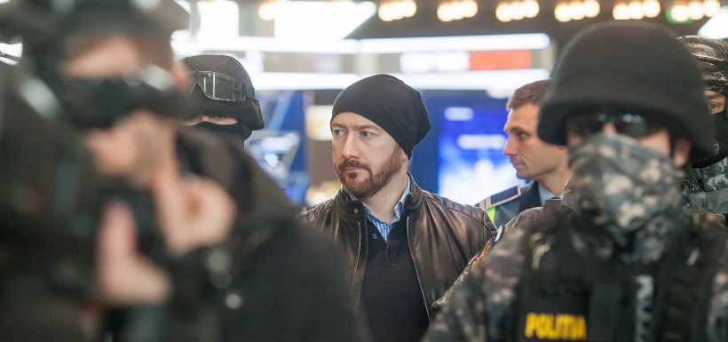 Chilean economist Garay is escorted by law enforcement officers as he is extradited from Romania to Chile