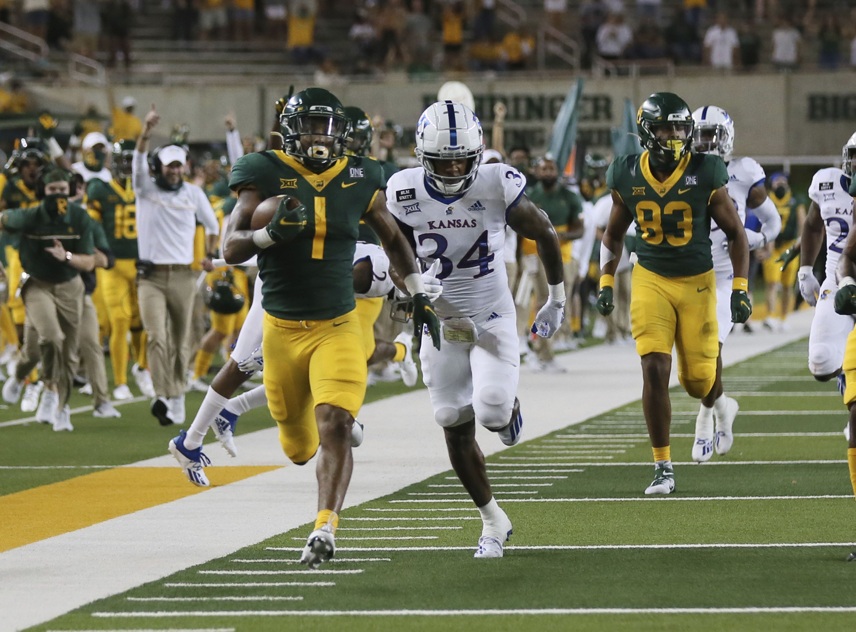 Baylor running back Trestan Ebner (1) leaps over TCU placekicker