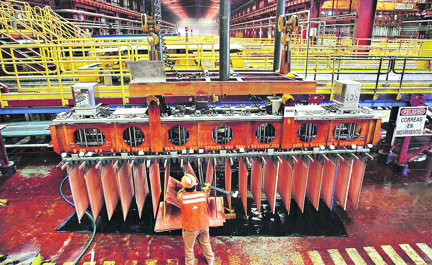 Miner checks copper cathodes at copper cathodes plant inside La Escondida copper mine near Antofagasta