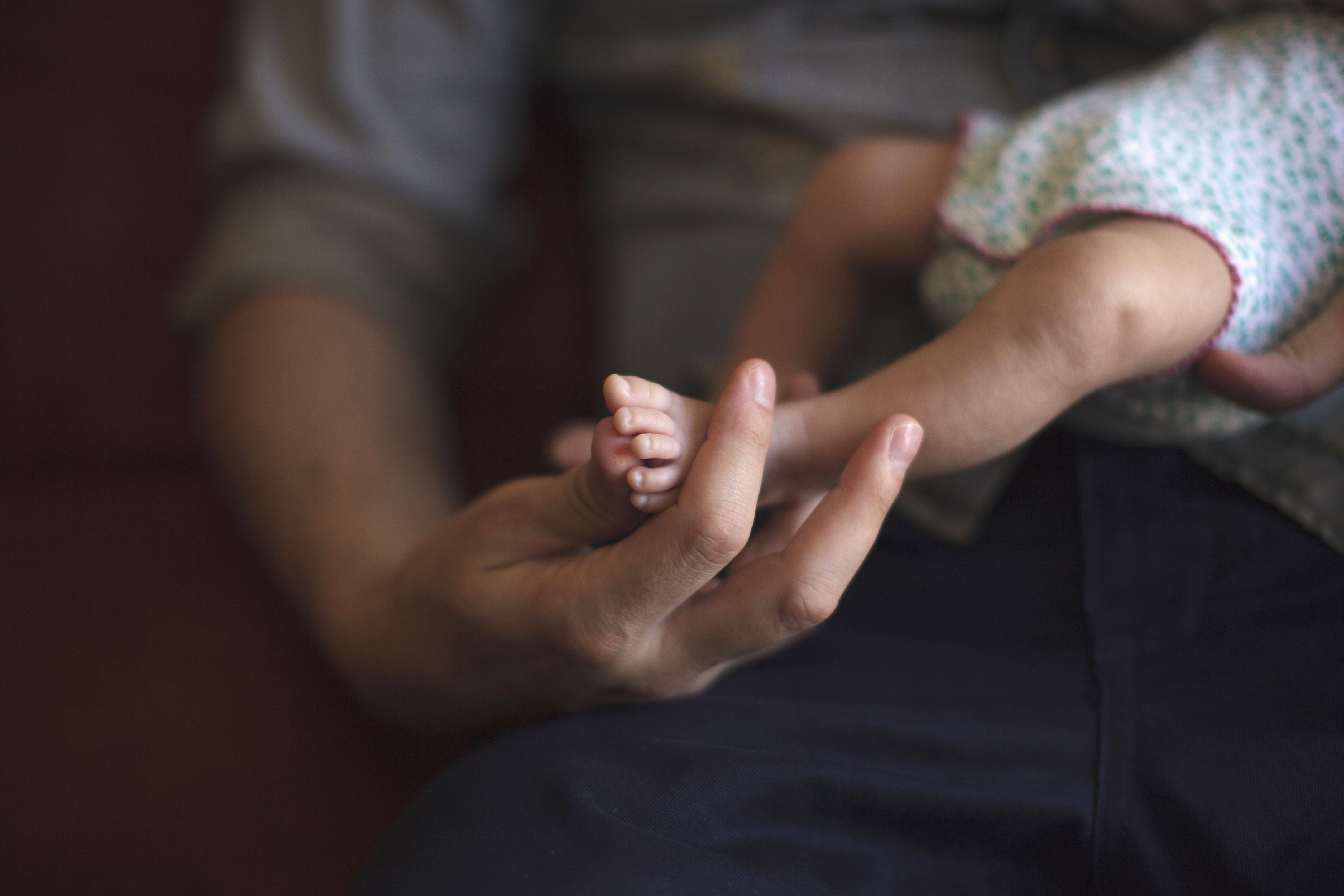 Antonio Fernandez holds one of his twins, daughter Olivia, in the house where he lives with husband Luis Delgado in Cancun