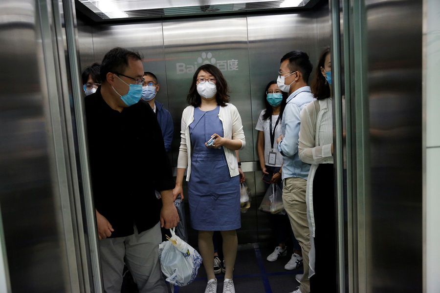 Employees wearing face masks are seen inside an elevator at Baidu's headquarters in Beijing