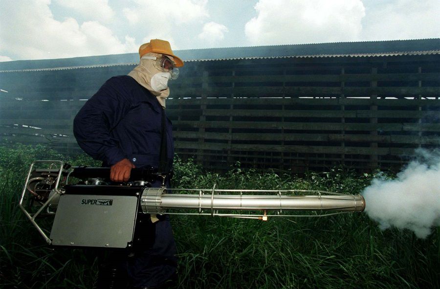 A HEALTH OFFICER SPRAYS ANTI-MOSQUITO FOG AT A PIG FARM IN SUNGAI NIPAH.