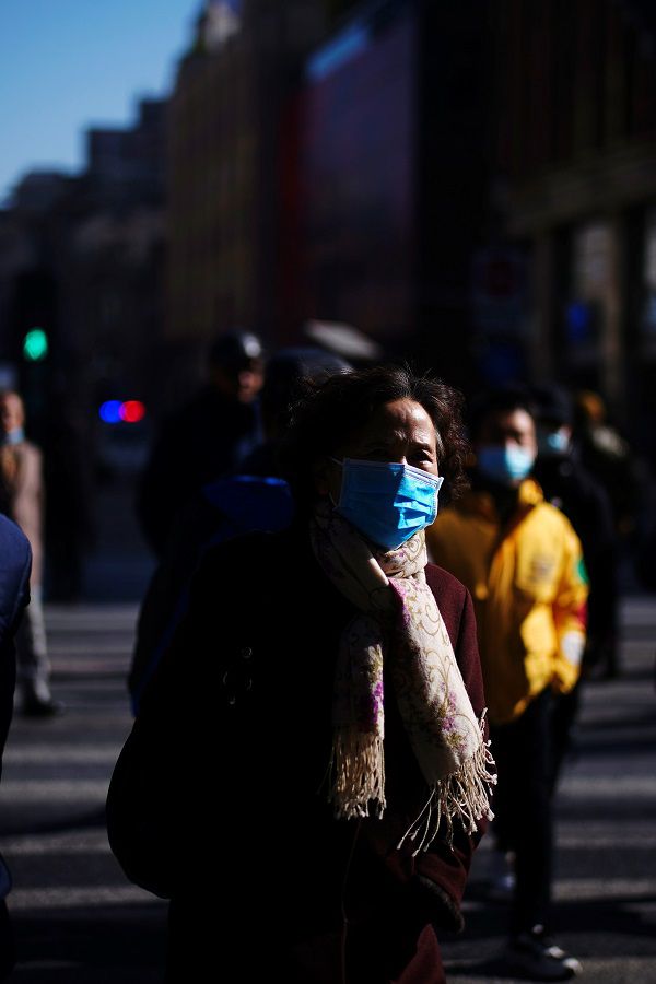 People wearing face masks walk on a street following an outbreak of the coronavirus disease (COVID-19) in Shanghai