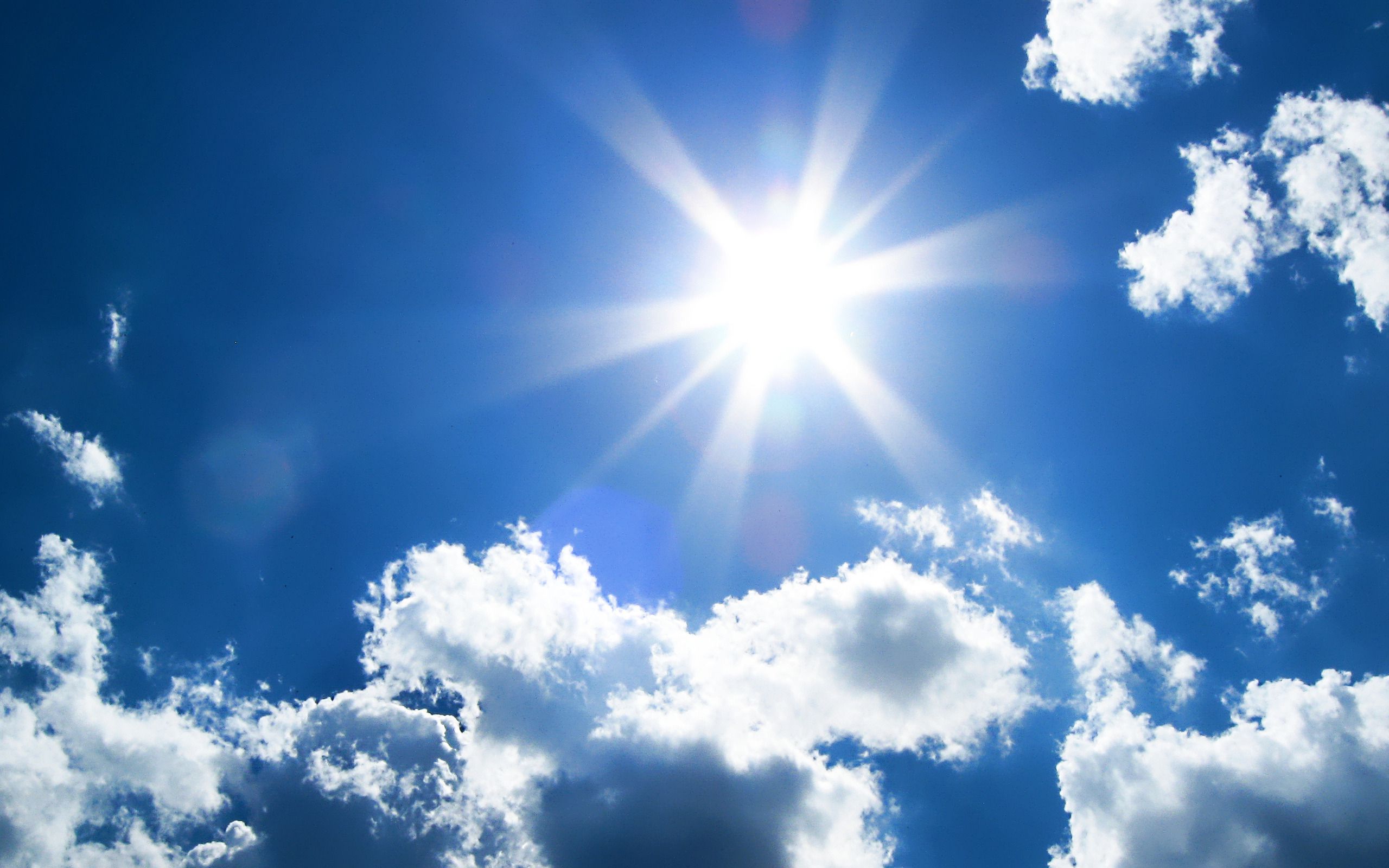 Cute puffy small white clouds on a sunny aqua blue sky Water