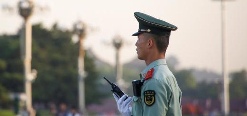 A paramilitary policeman surveys Tiananmen Square in Beijing