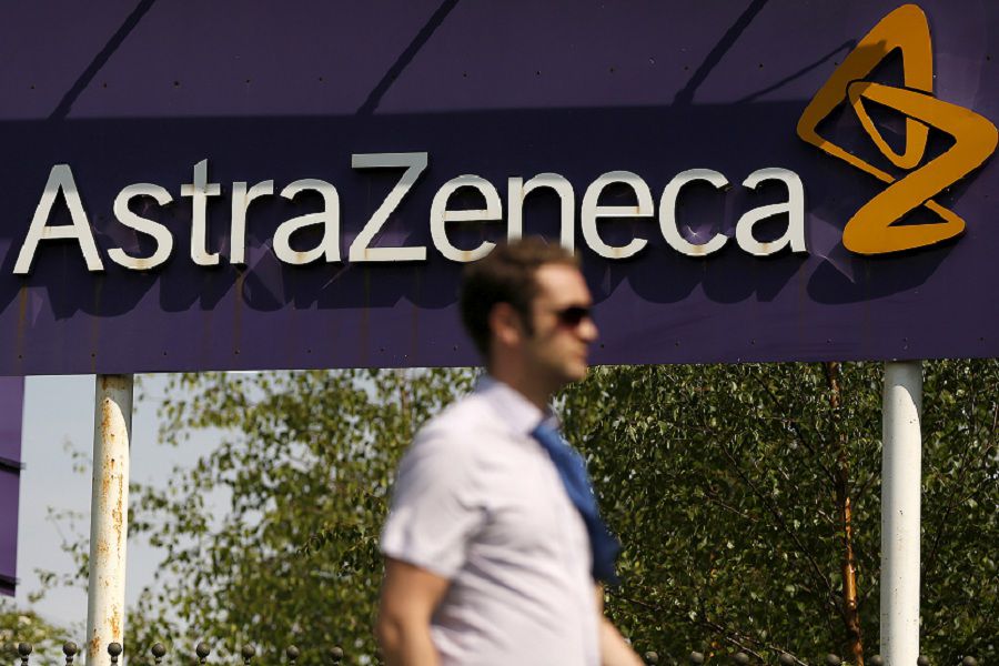 FILE PHOTO: A man walks past a sign at an AstraZeneca site in Macclesfield