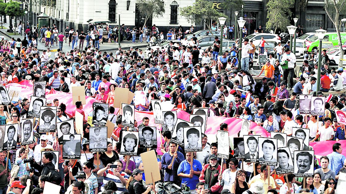 People holding pictures of victims of the guerrilla conflict in the 80s and 90s protest after Peruvian President Pedro Pablo Kuczynski pardoned former President Alberto Fujimori in Lima