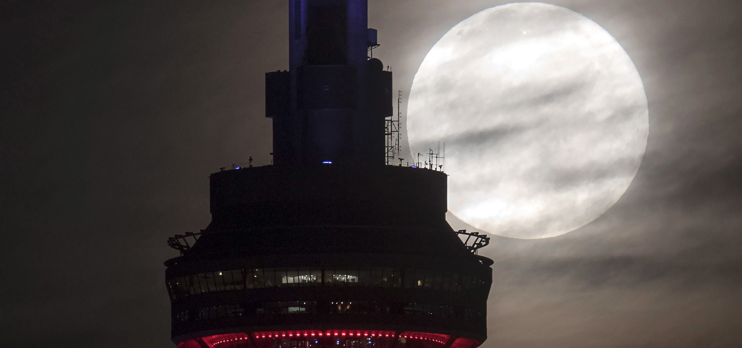 The supermoon sets behind the CN tower in Toronto on Monday, Nov.