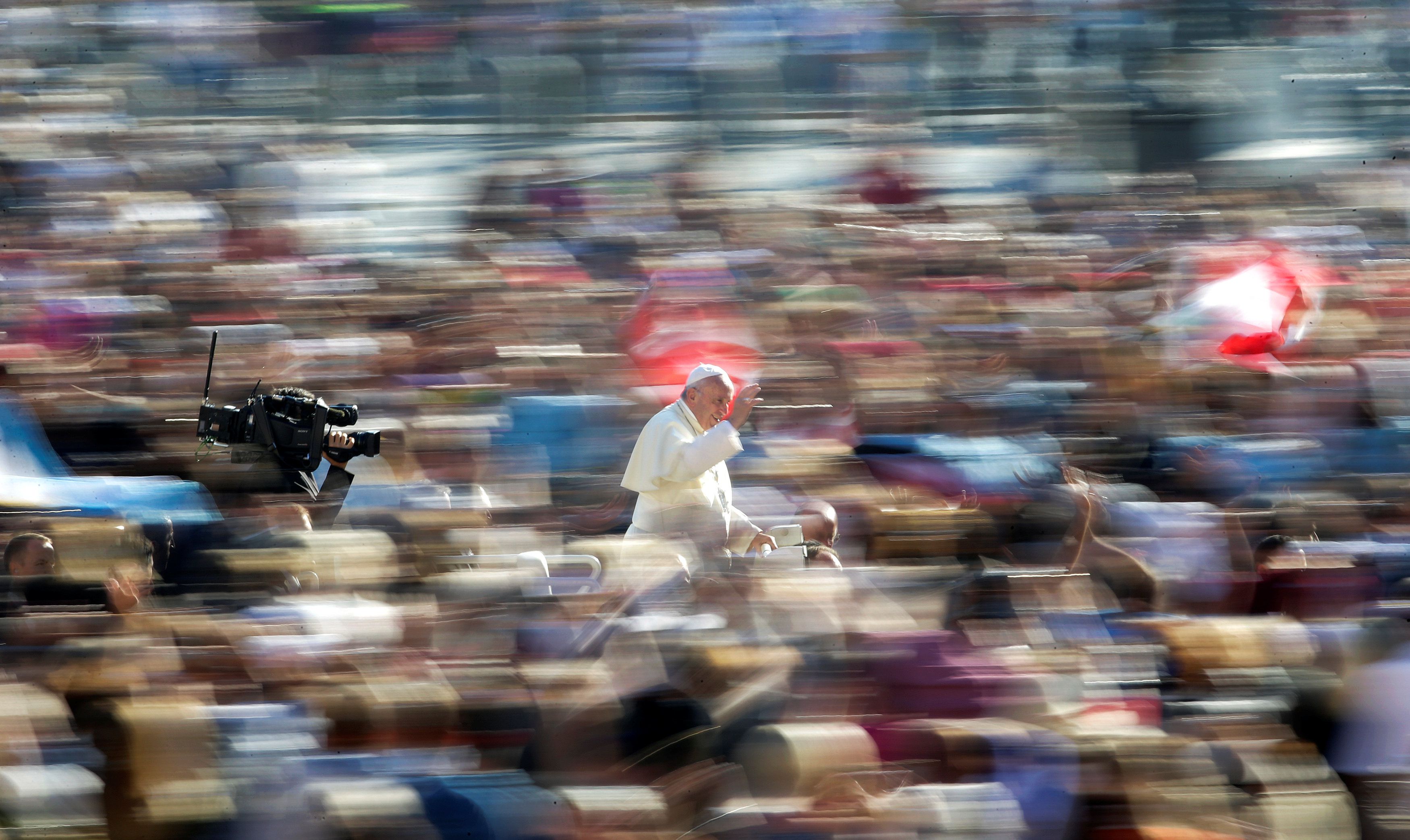 Pope Francis waves as he arrives to lead the Wednesday general audience in Saint Peter's square at the Vatican