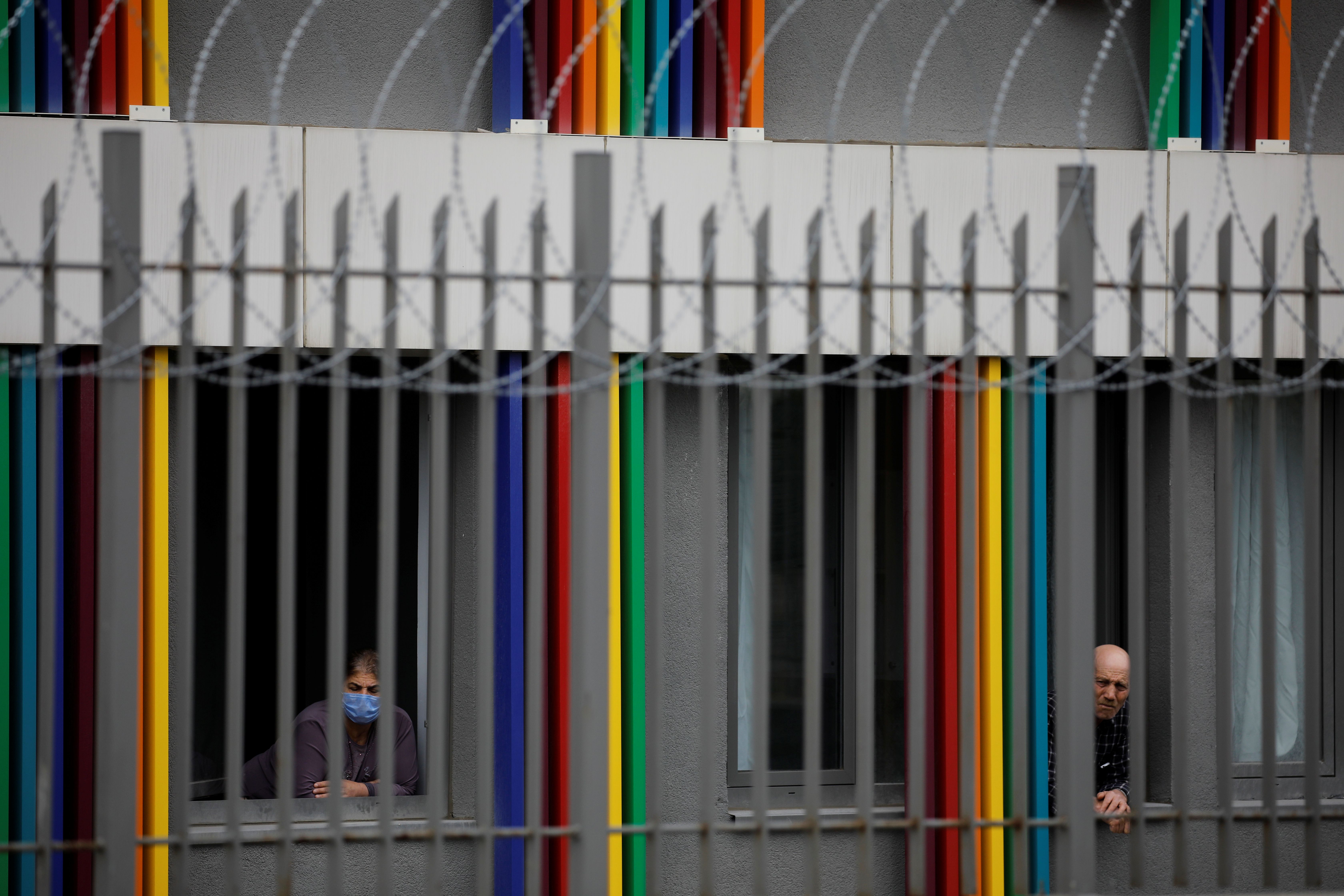 Man and a woman looks out from a dormitory under quarantine in Istanbul