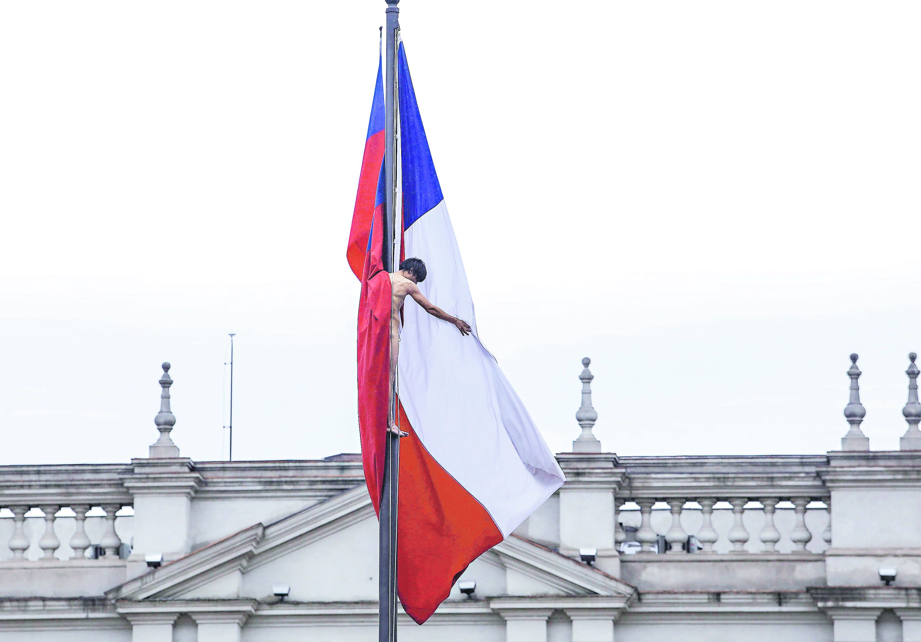 Hombre se sube desnudo a bandera frente a La Moneda