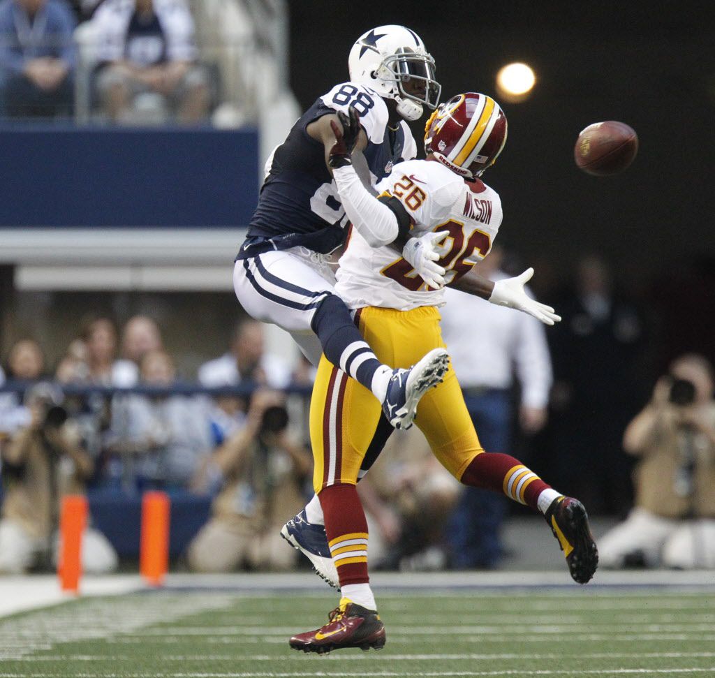 Dallas Cowboys wide receiver Dez Bryant (88) eludes Washington Redskins  defenders to take a Tony Romo pass for 85 yards and a touchdown in the  third quarter at Cowboys Stadium in Arlington