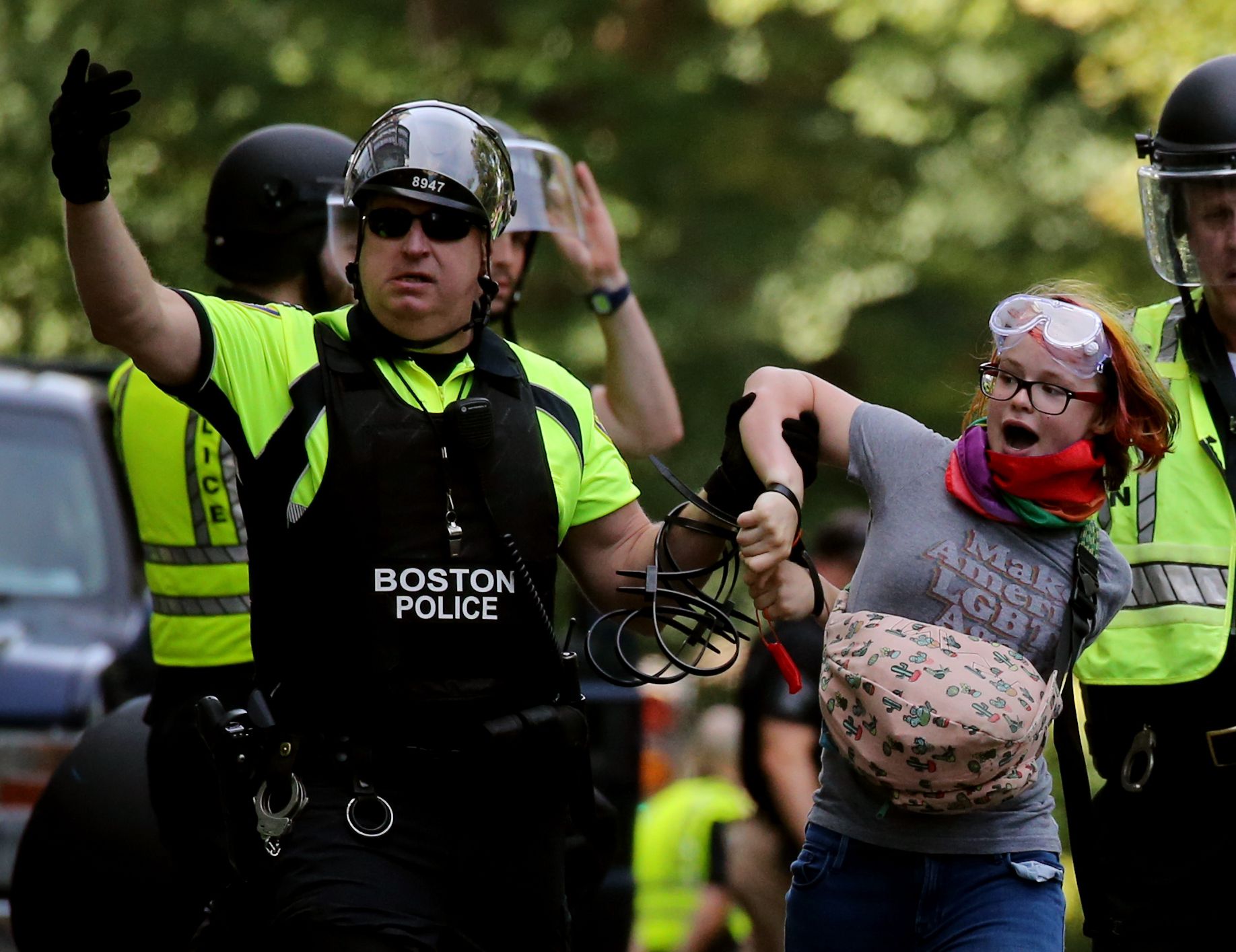 A police officer detains a climate activist after she sprayed