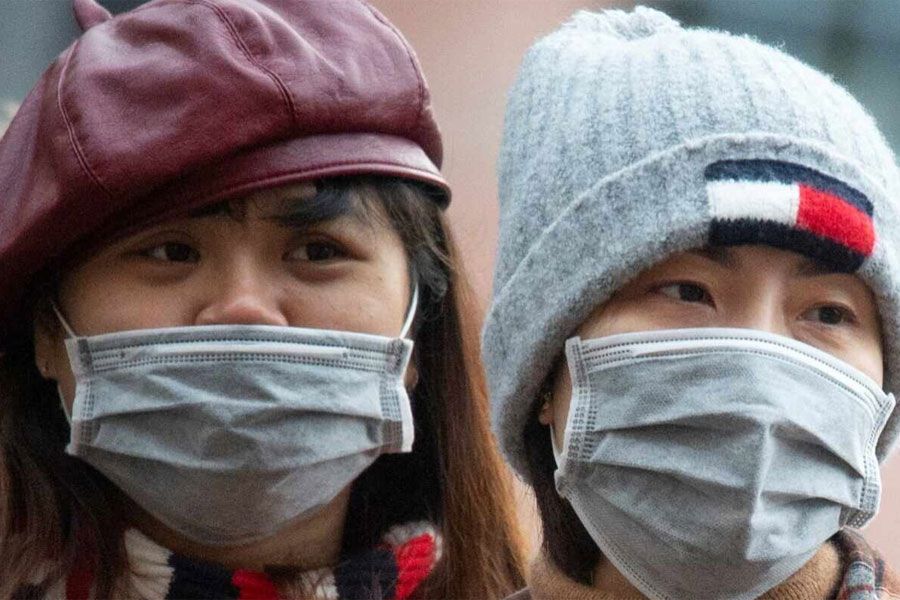 La foto muestra dos personas con mascarillas