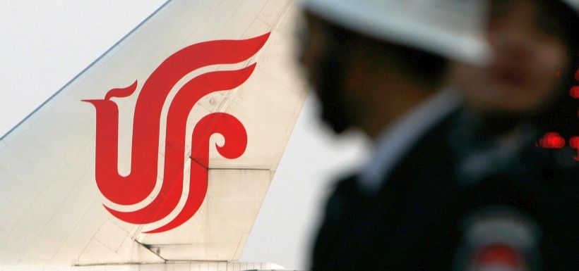 FILE PHOTO - Security guards stand near an Air China aircraft on the tarmac of Shanghai Pudong International Airport