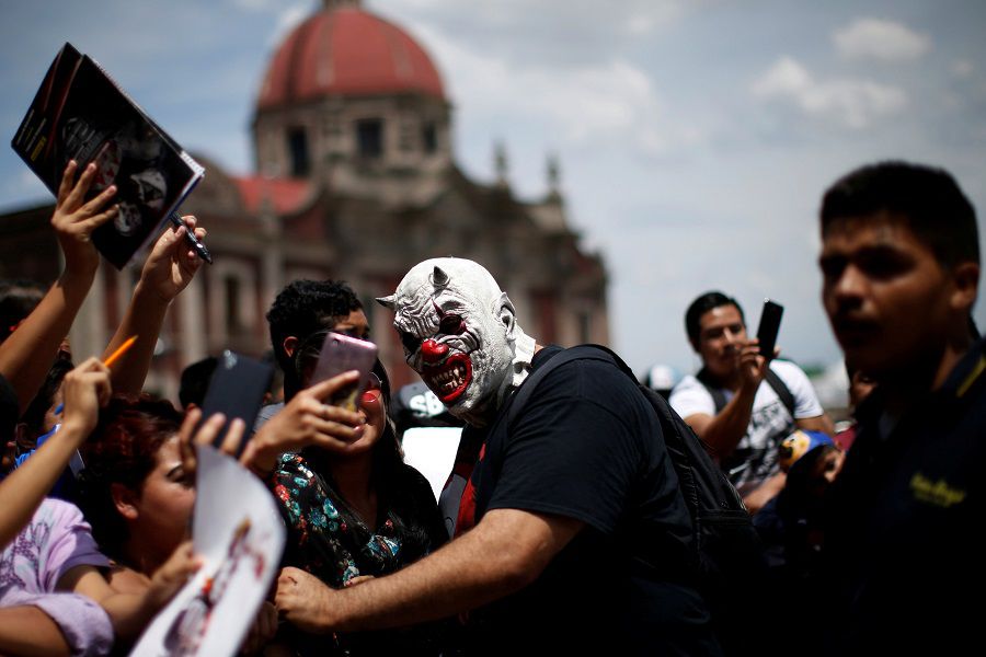 A Mexican wrestler known as Murder Clown sign autographs during the annual lucha libre pilgrimage to the Basilica of Our Lady Guadalupe in Mexico City