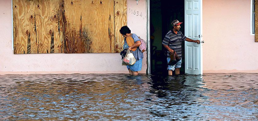 na pareja deja su casa inundada luego del paso de Irma, en Fort Myers, Florida.