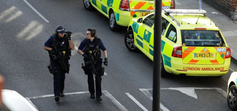 Police officers walk on the road near Parsons Green tube station in London