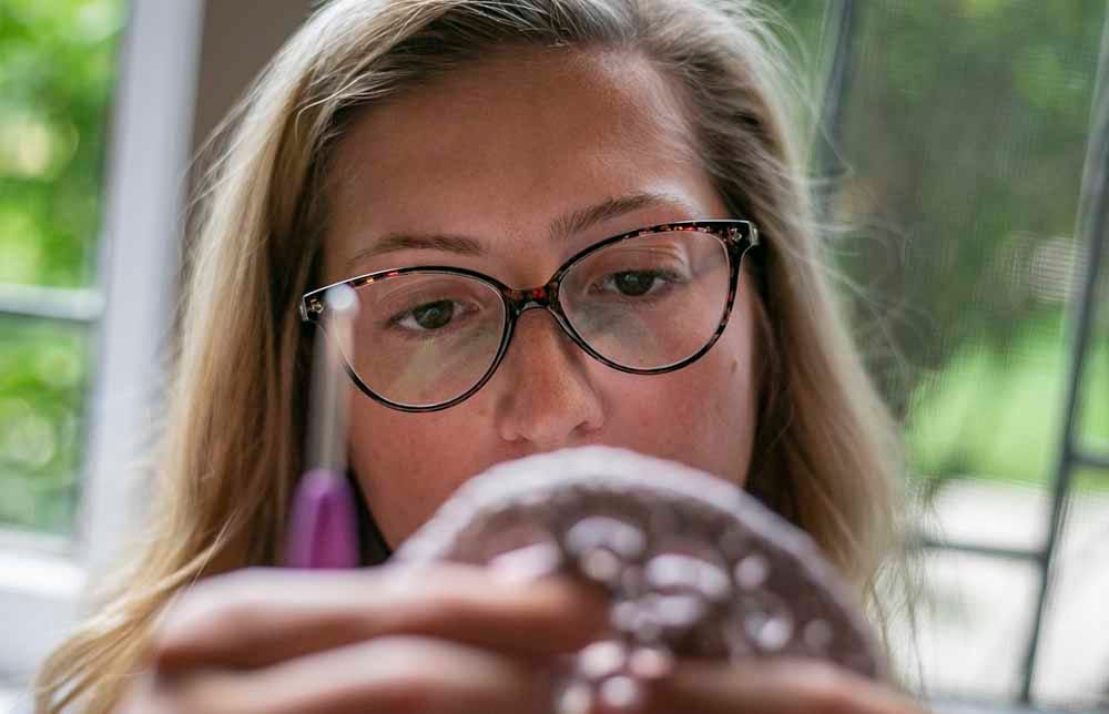 Mandy Mcsherry examines her project while drinking a Bloody Mary, Sunday, July 28, 2019, in the Indianapolis home of a group