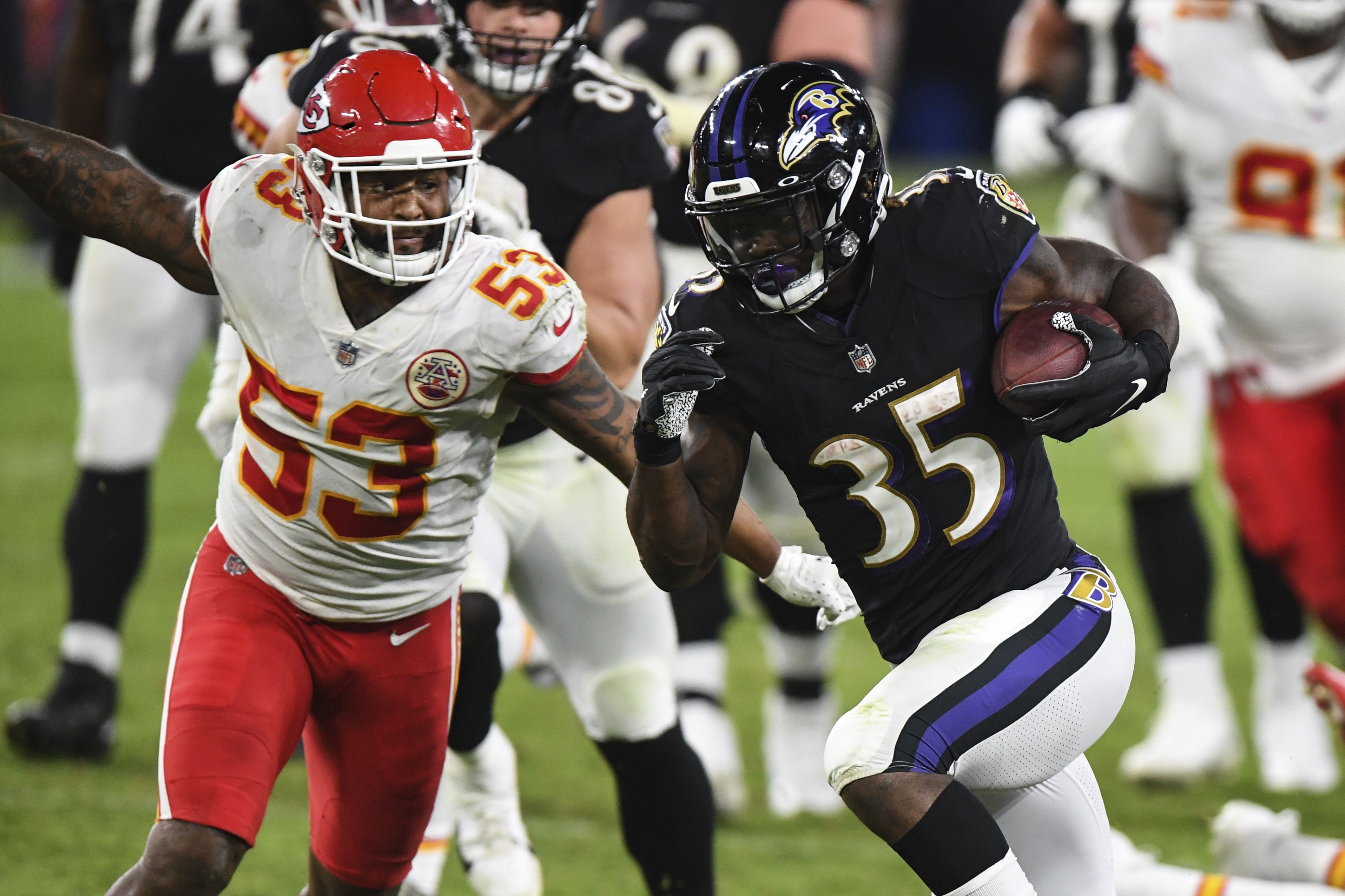 Baltimore Ravens running back Gus Edwards runs with the ball