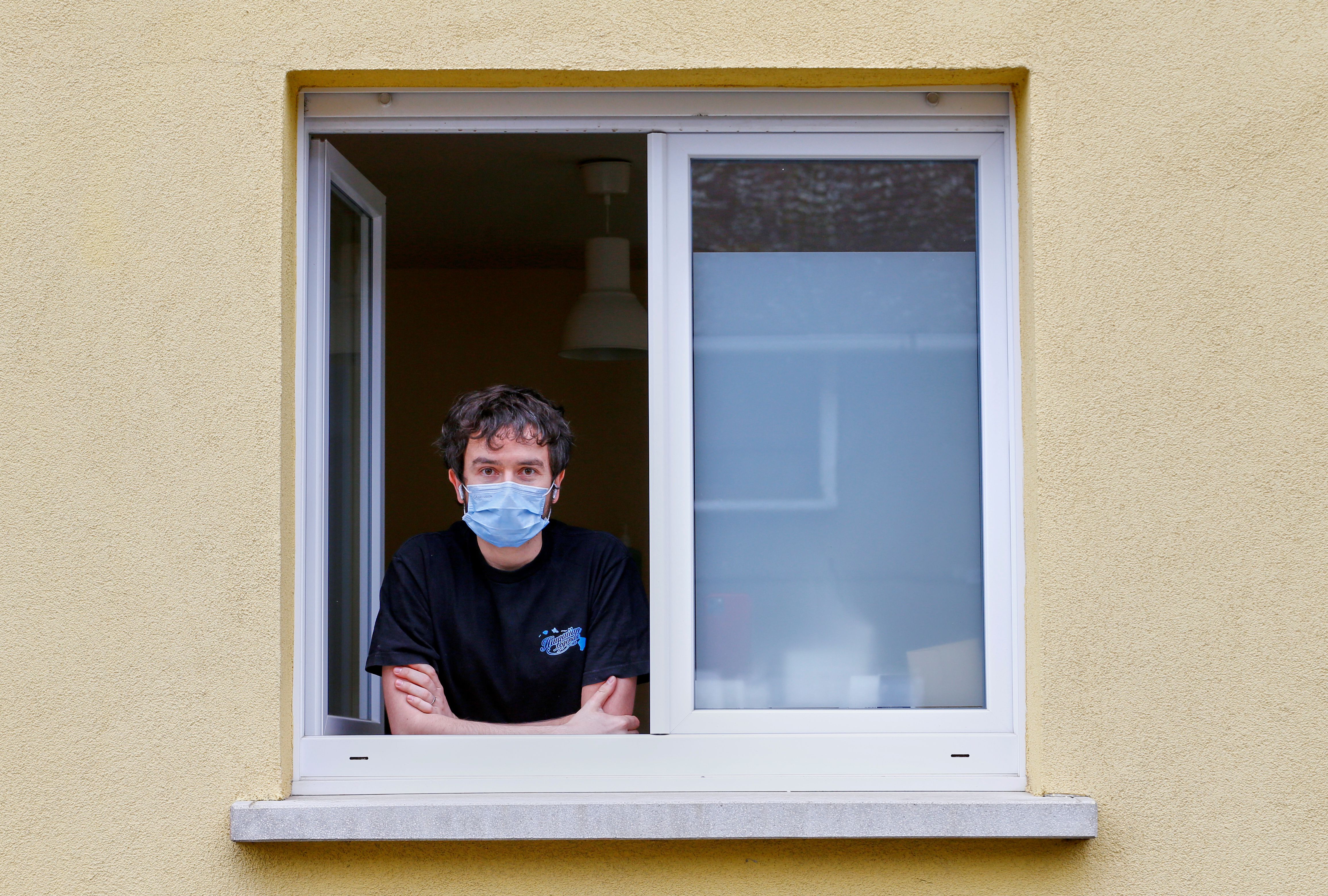 FILE PHOTO: Jonathan Peterschmitt poses at his window during his home quarantine in Bernwiller