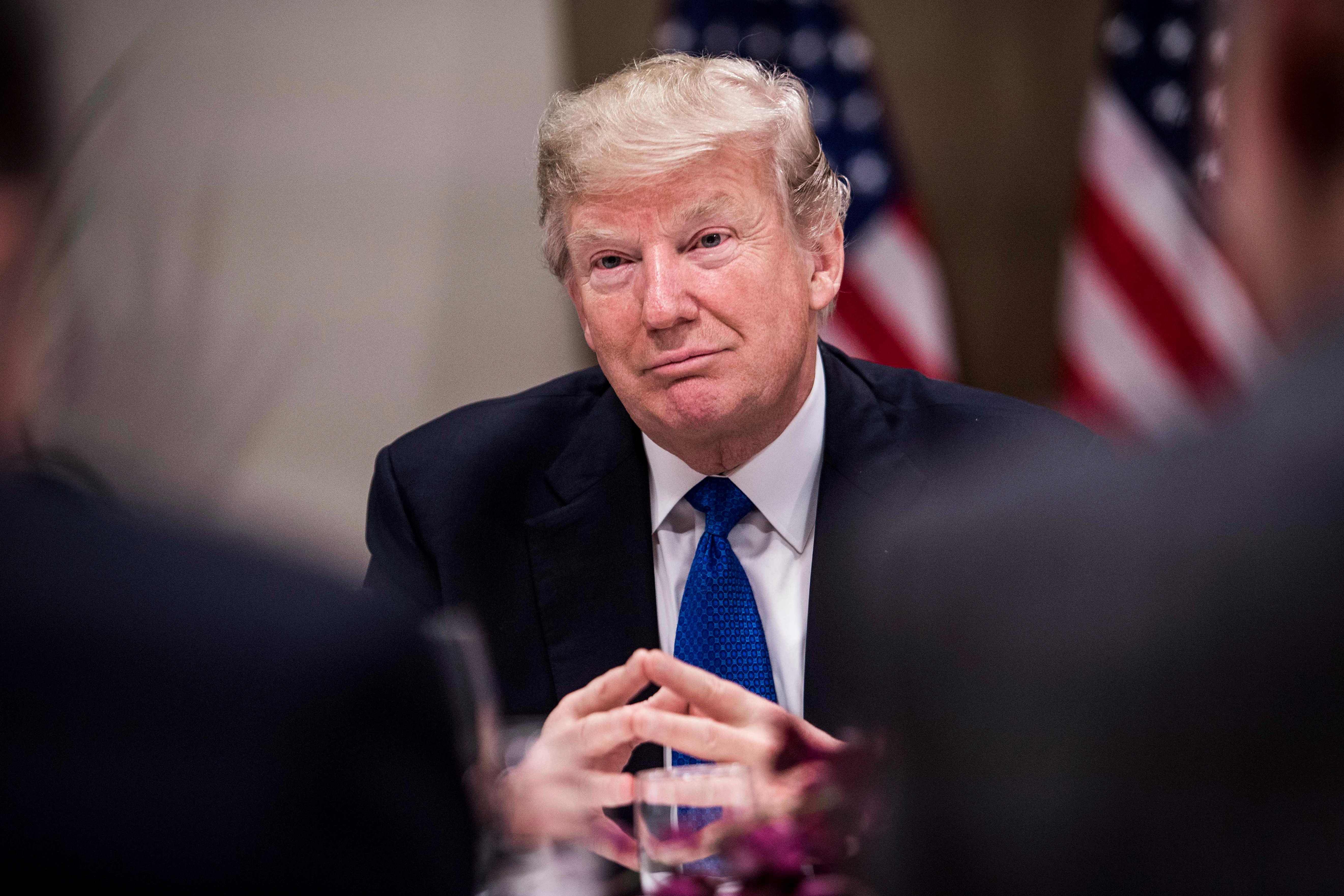 US President Donald Trump listens to a speaker during a working dinne