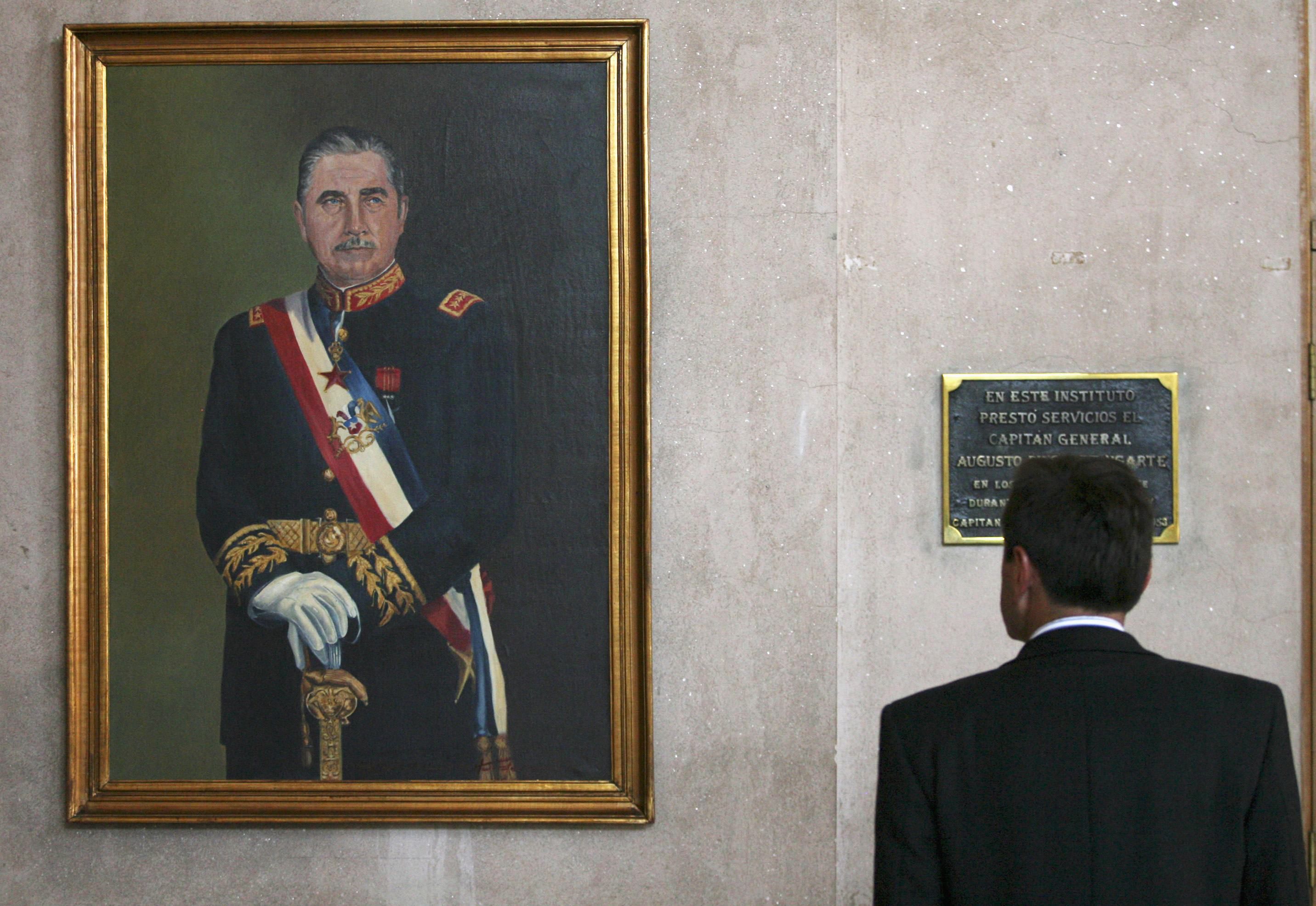 A man pauses to view a portrait of former Chilean dictator Augusto Pinochet during Pinochet's wake inside the Military College in Santiago