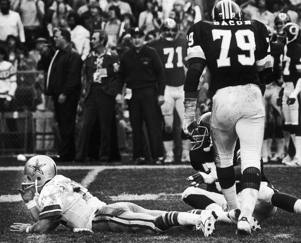 Dallas Cowboys quarterback Roger Staubach (12) looks for a receiver during  the NFC Championship game against the Washington Redskins at RFK Stadium in  Washington, DC on December 31, 1972. Blocking for Staubach