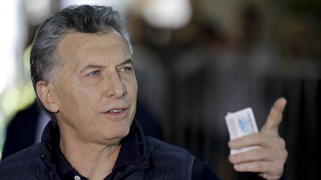 Argentina's President Mauricio Macri holds his ID after casting his v