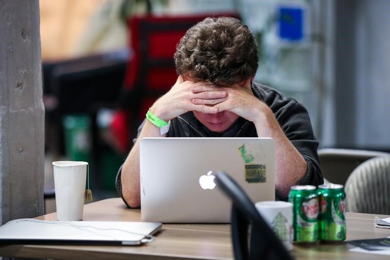 A young man works at his Apple computer during a weekend Hackathon event in San Francisco