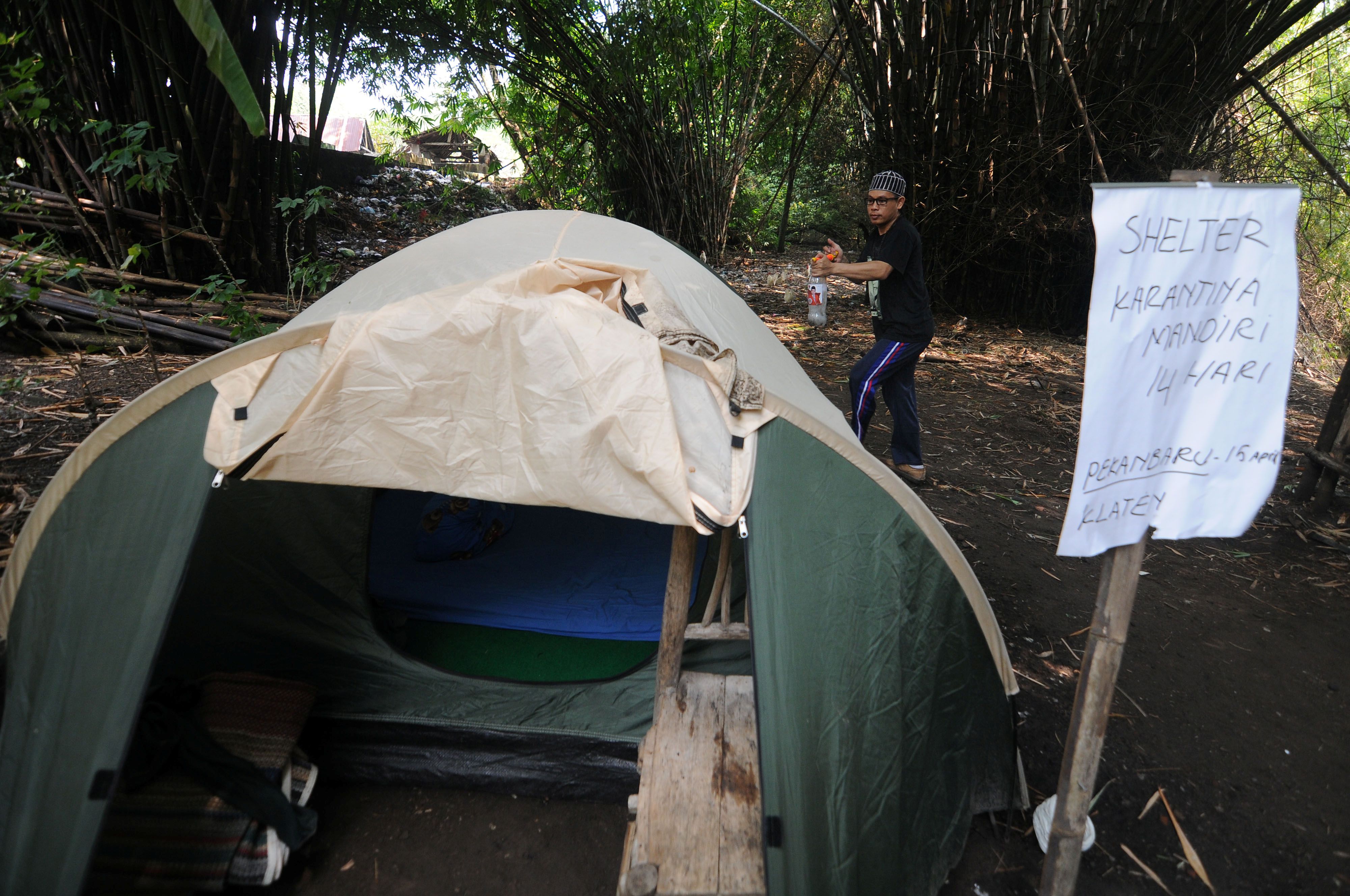 Abdullah Al Mabrur sprays disinfectant on a tent he used for a self-quarantine on a river bank after he came back from Pekanbaru, to prevent the spread of the coronavirus disease (COVID-19) in Klaten