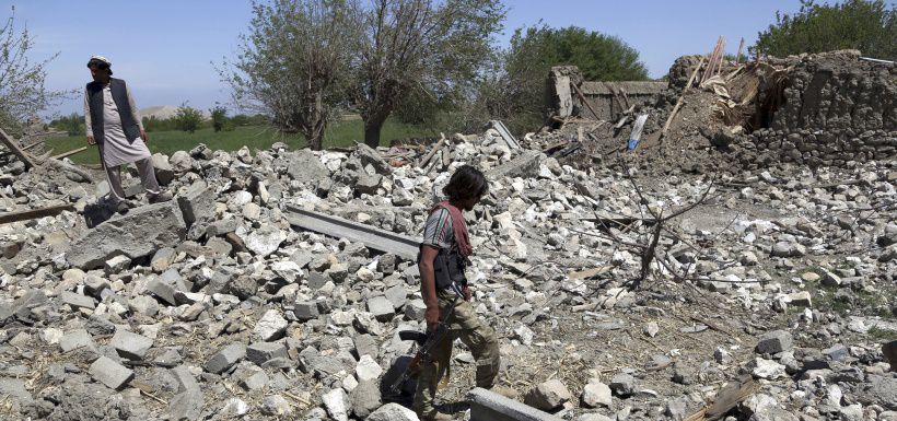 An Afghan security police walks at the destroyed house after an opera