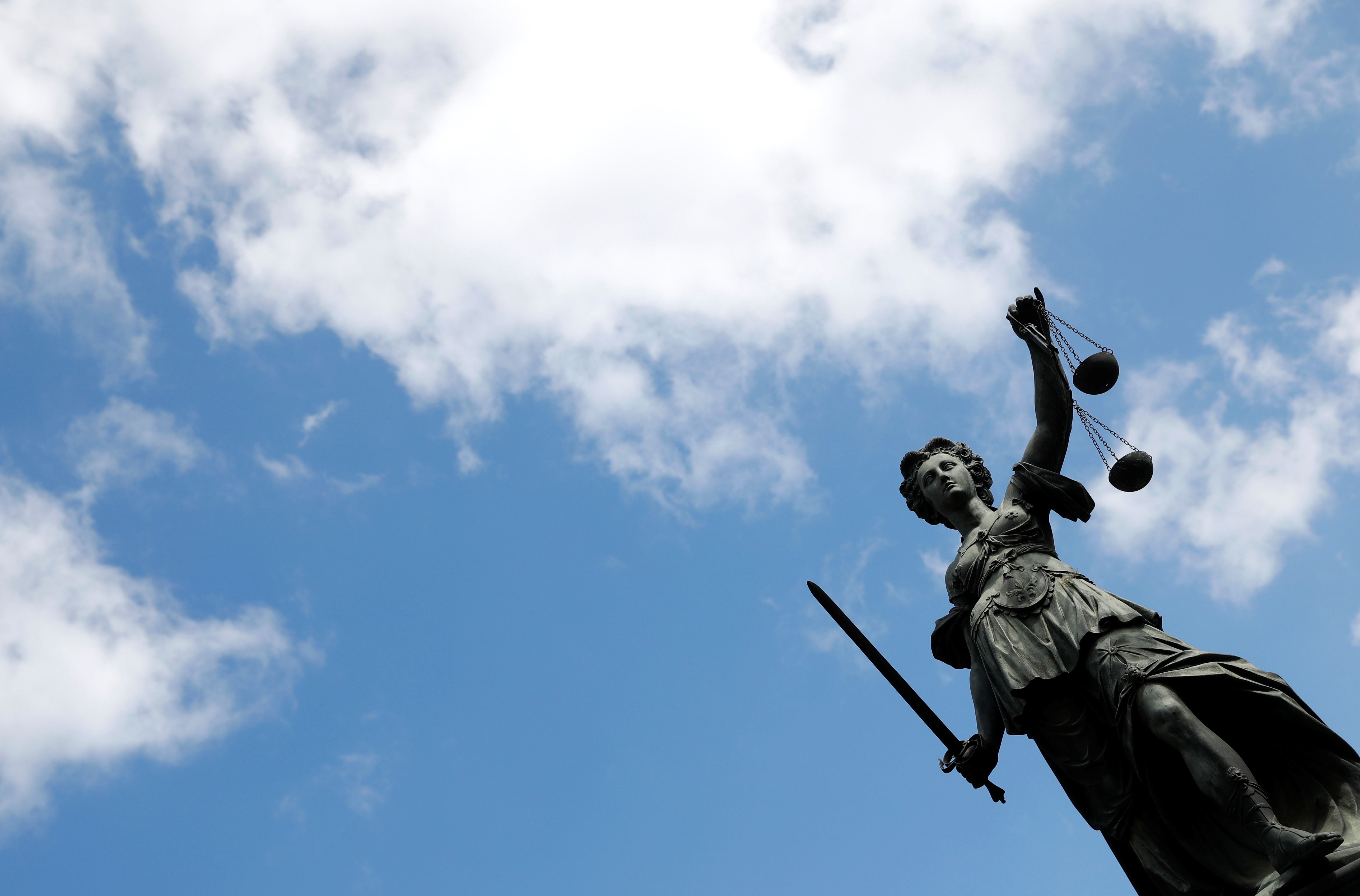 The statue of the goddess of Justice " Justitia " is sen in front of the famous Frankfurt landmark  " Roemer " in  Frankfurt