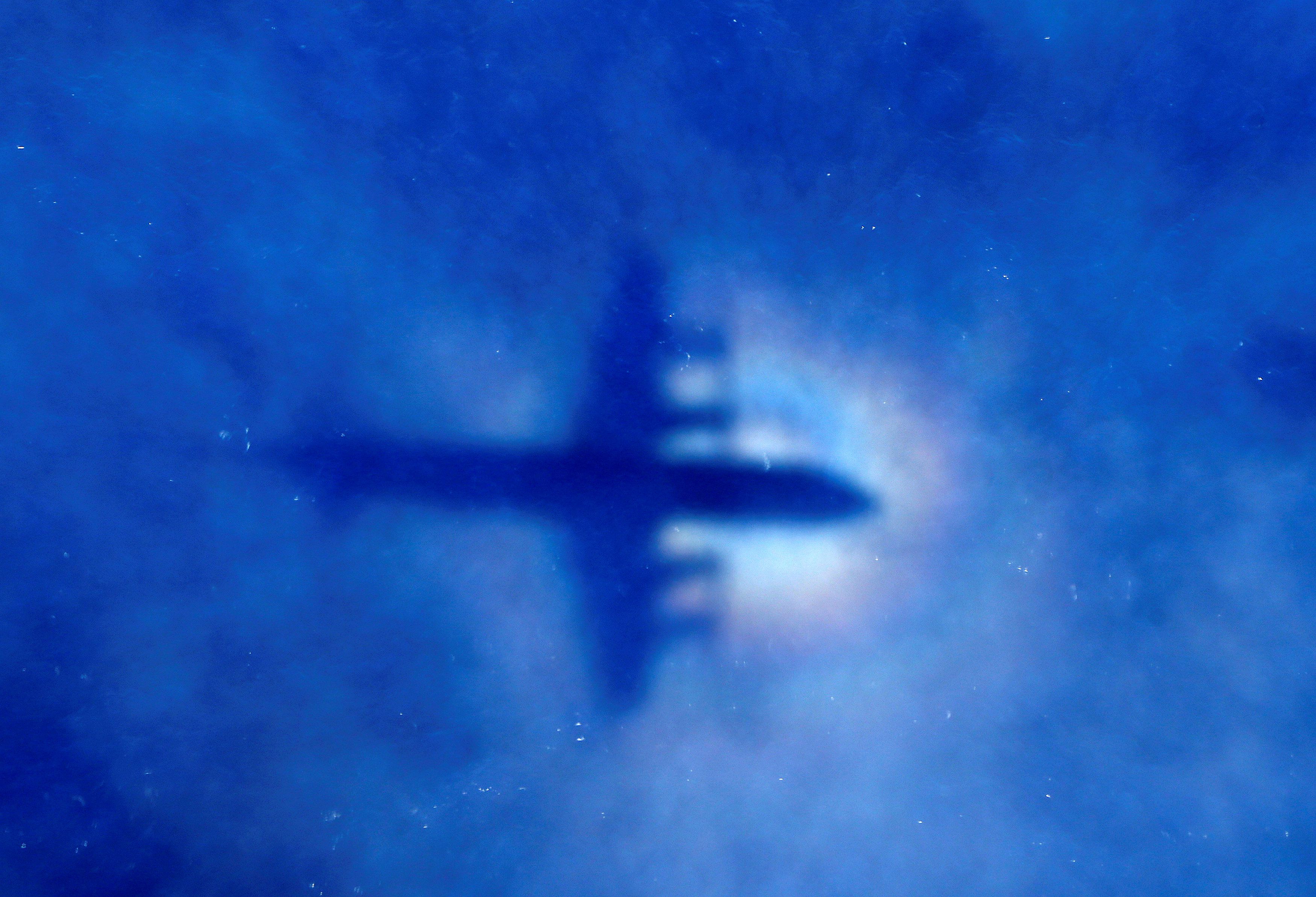 FILE PHOTO: The shadow of a search aircraft can be seen on low-level clouds as it flies over the southern Indian Ocean