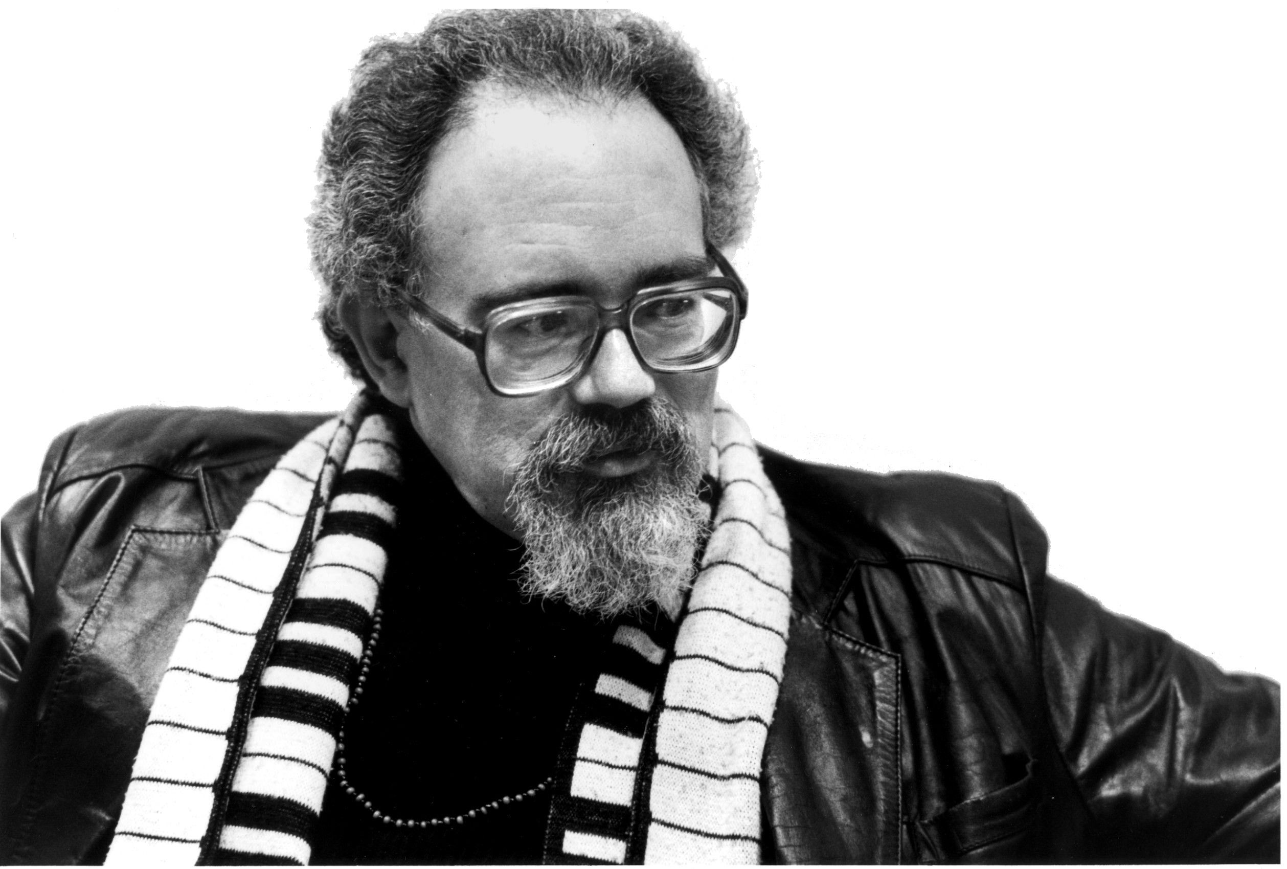 Bearded man wearing black leather jacket and sunglasses adjusting