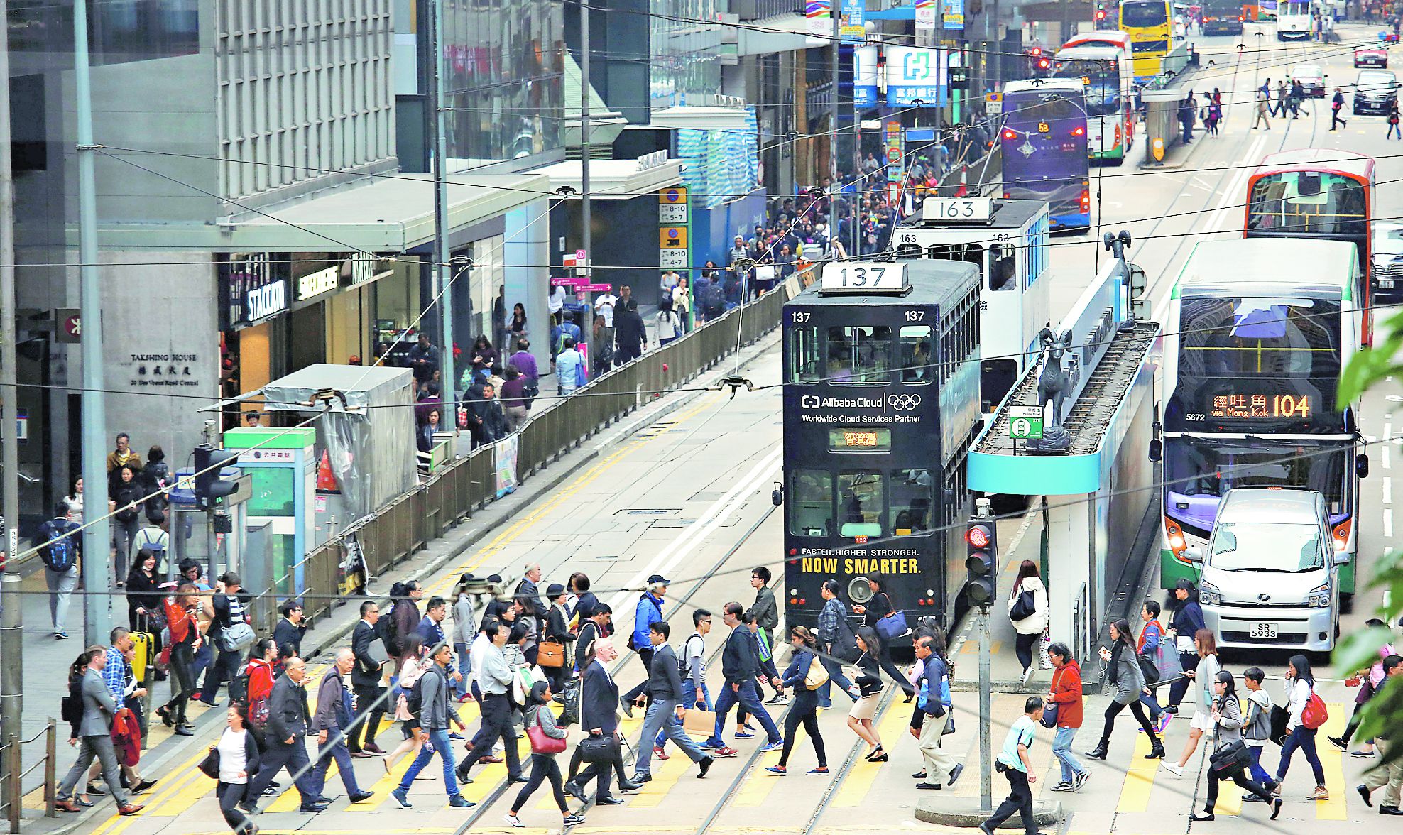 People cross a street at the financial Central district in Hong Kong