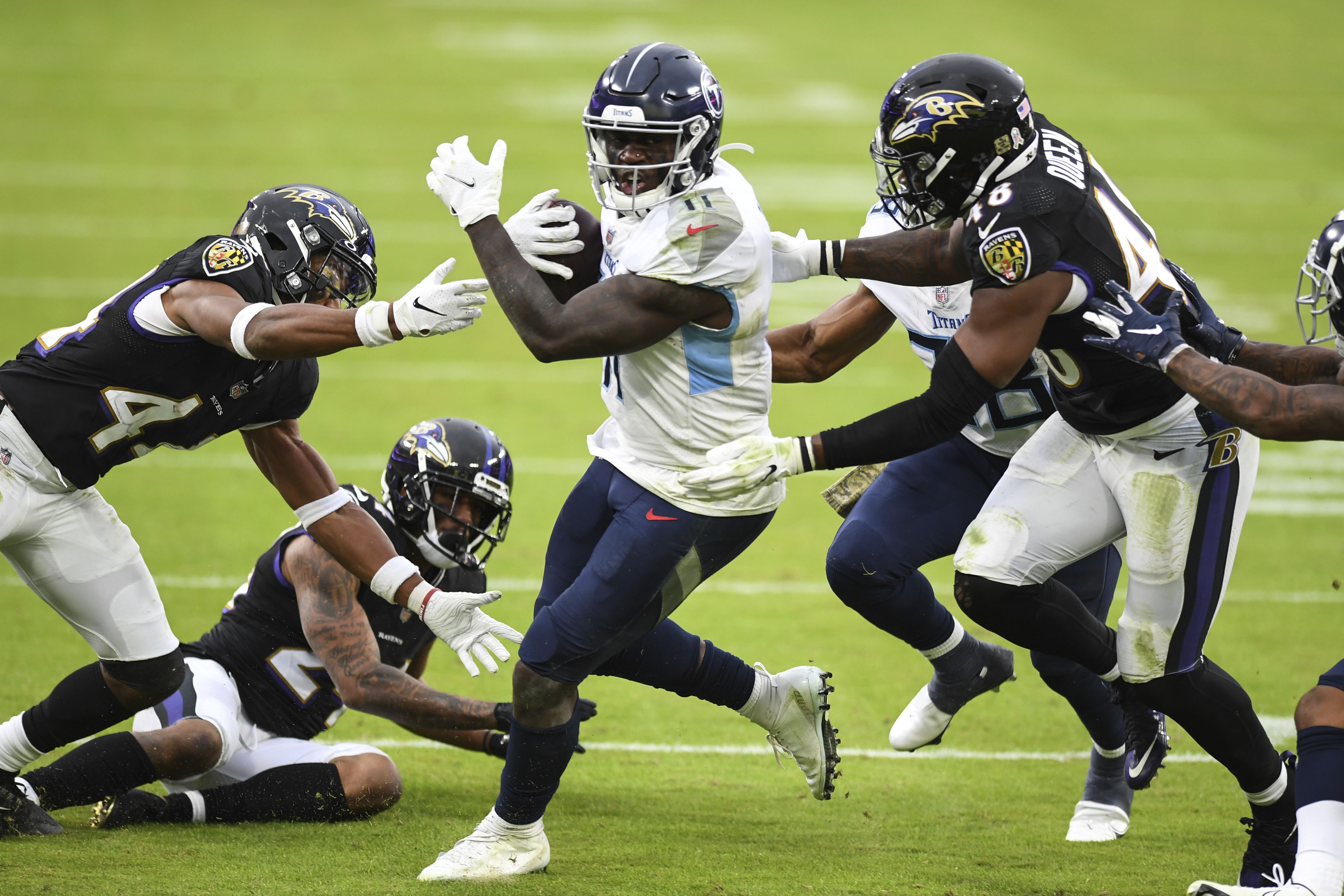 Lamar Jackson of the Baltimore Ravens wipes his face during a time