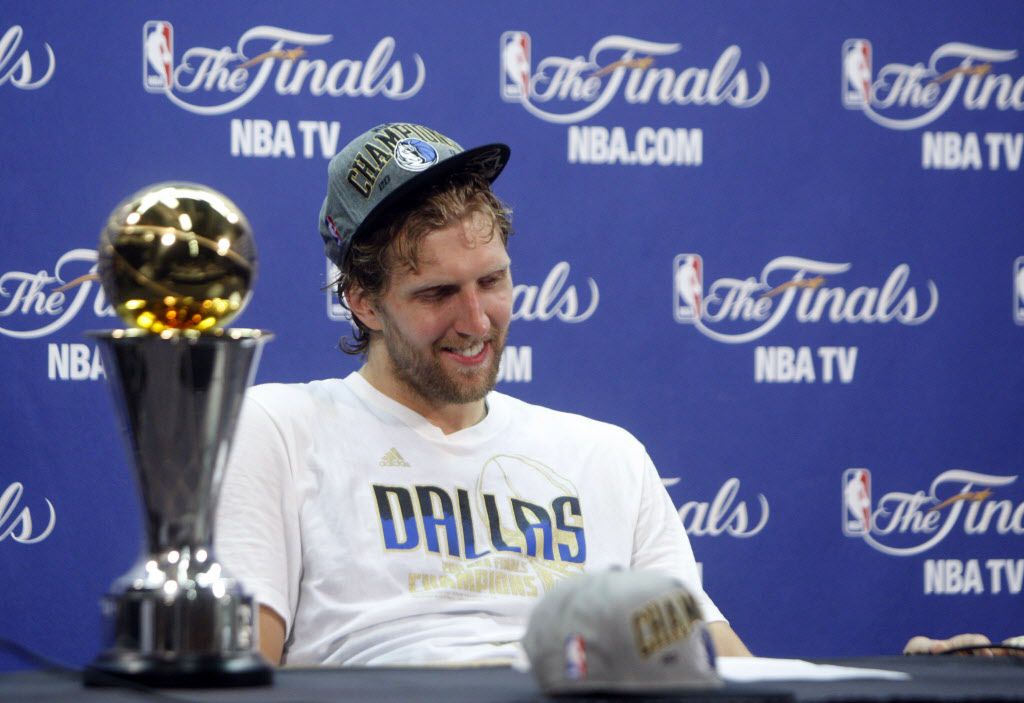 Dirk Nowitzki of the Mavericks holds the championship trophy after  defeating the Heat during Game 6 of the NBA Finals at the AmericanAirlines  Arena in Miami, Florida, Sunday, June 12, 2011. The