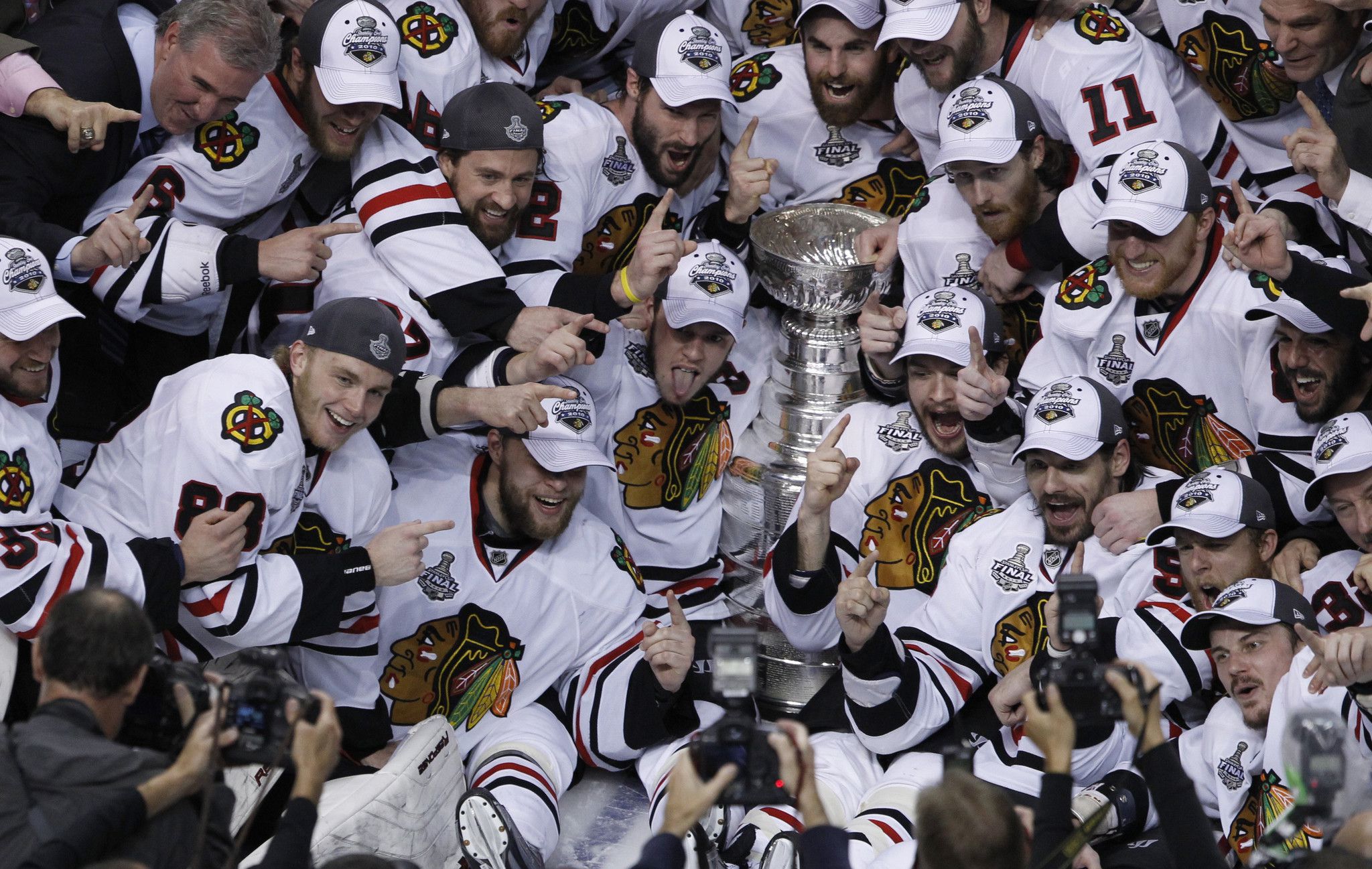 Marian Hossa, center, poses for photos with teammates Duncan Keith, left,  Brent Seabrook, second from left, Niklas Hjalmarsson, third from left,  Patrick Sharp, third from right, Patrick Kane, second from right, and  Jonathan Toews during a Chicago