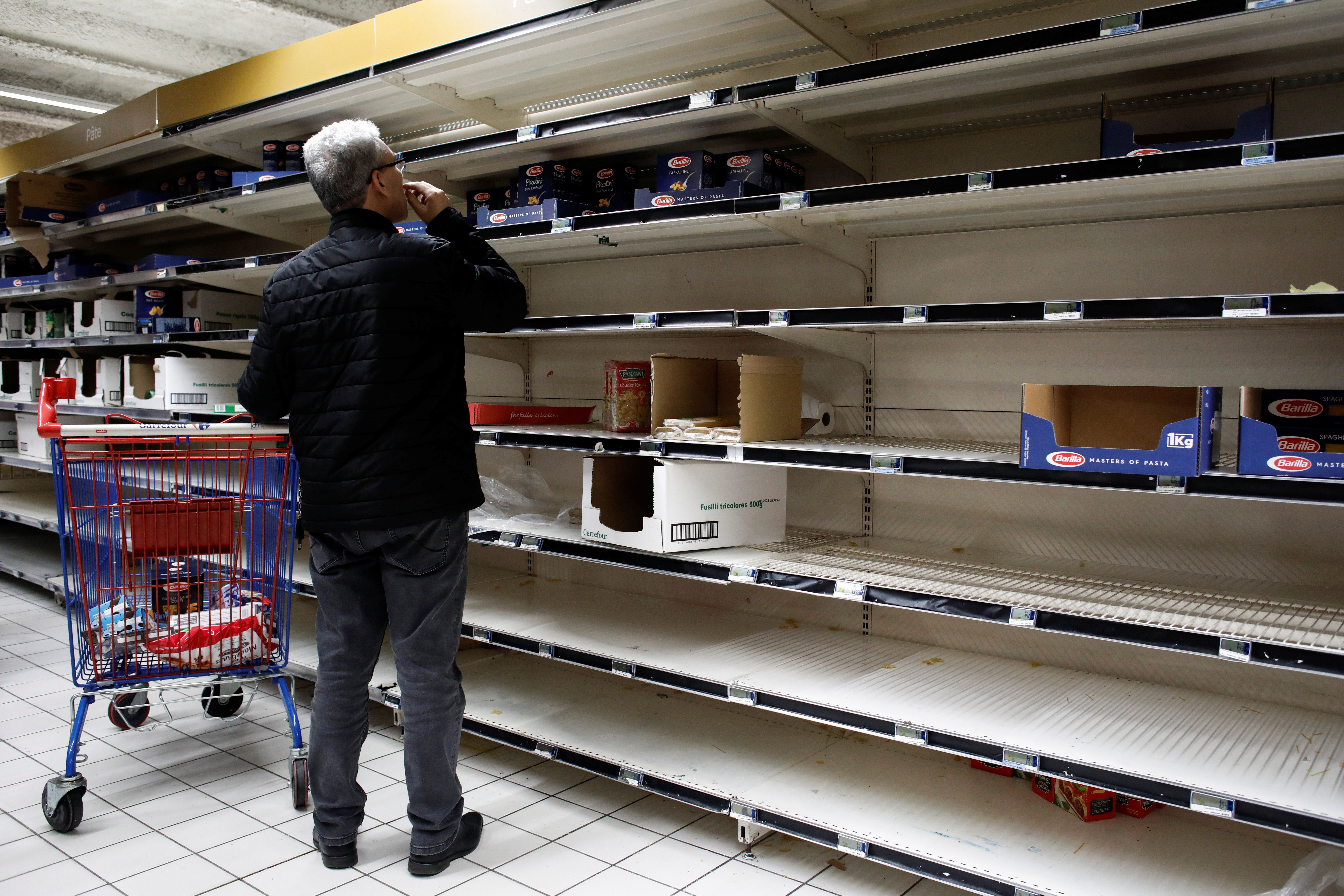 A view shows empty shelves at a Carrefour supermarket as people began stockpiling food in Gennevilliers, near Paris