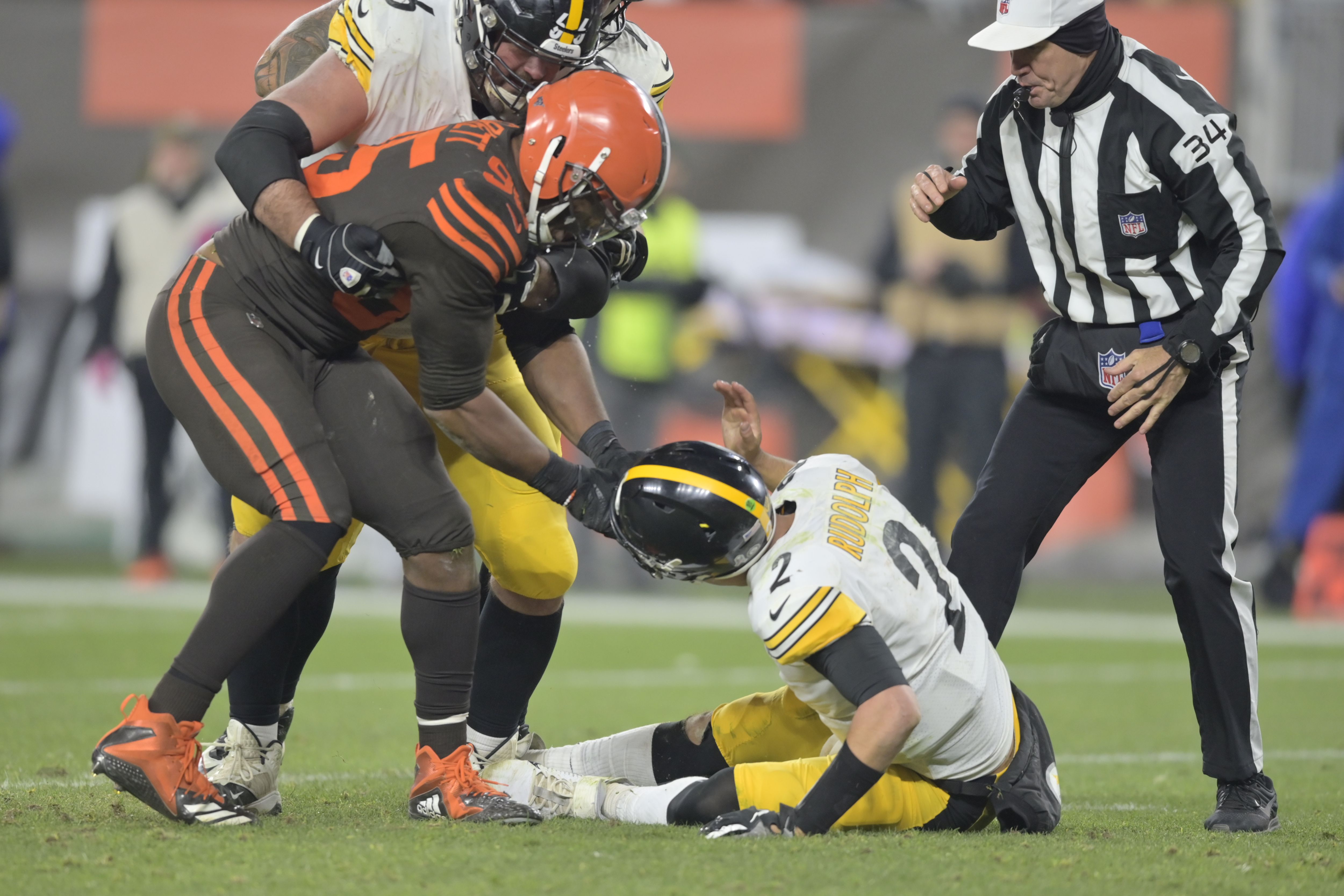 Cleveland Browns defensive end Myles Garrett (95) is taken down by  Pittsburgh Steelers offensive guard David DeCastro (66) and Maurkice  Pouncey (53) after pulling the helmet off quarterback Pittsburgh Steelers  quarterback Mason