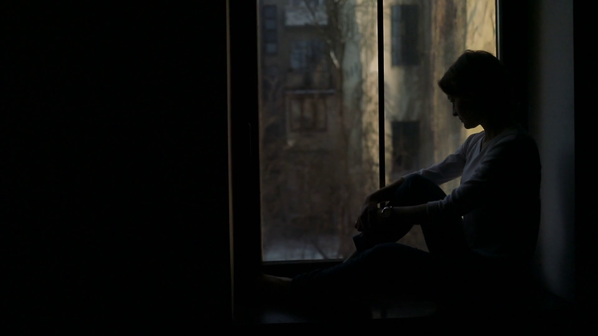 videoblocks-silhouette-of-sad-woman-sitting-on-the-sill-and-looking-out-the-window_hwqxdxial_thumbnail-full01