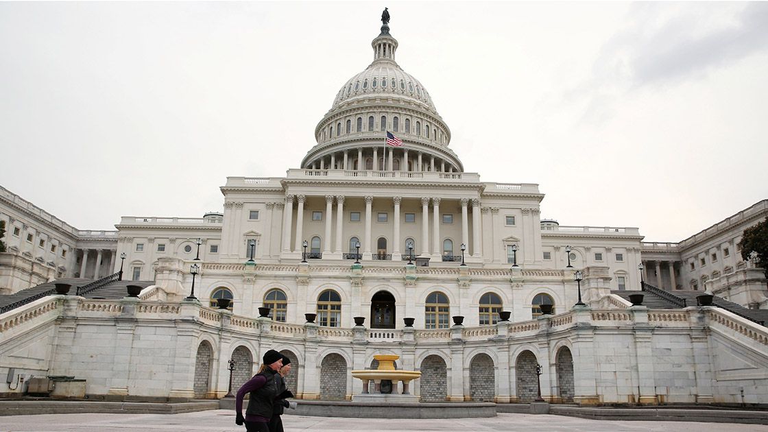 Runners stride past the U.S. Capitol building on the day of U.S. President Trump's State of the Union address to a joint session of the U.S. Congress at the Capitol in Washington