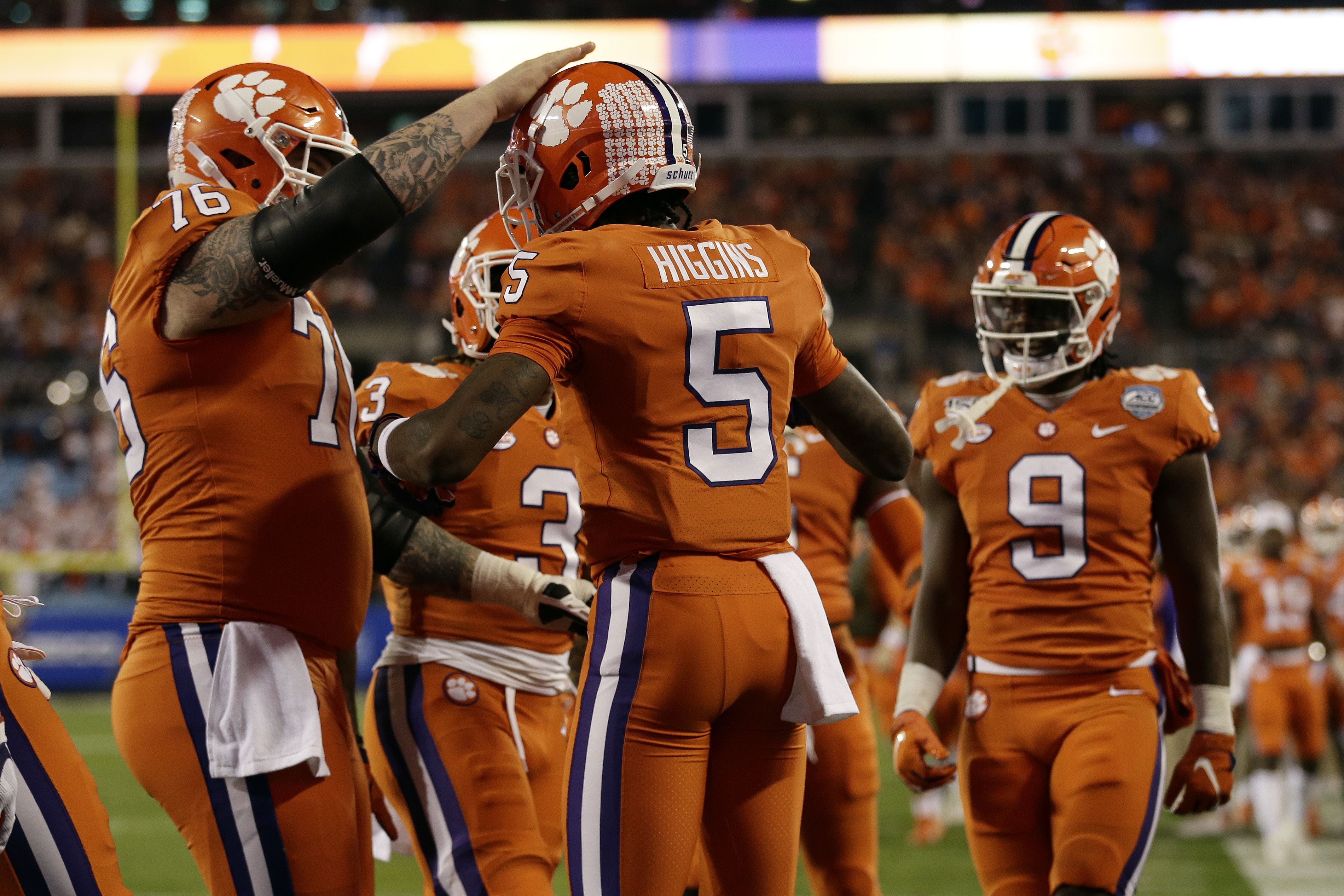 Clemson's Trevor Lawrence (16) congratulates Travis Etienne (9) on