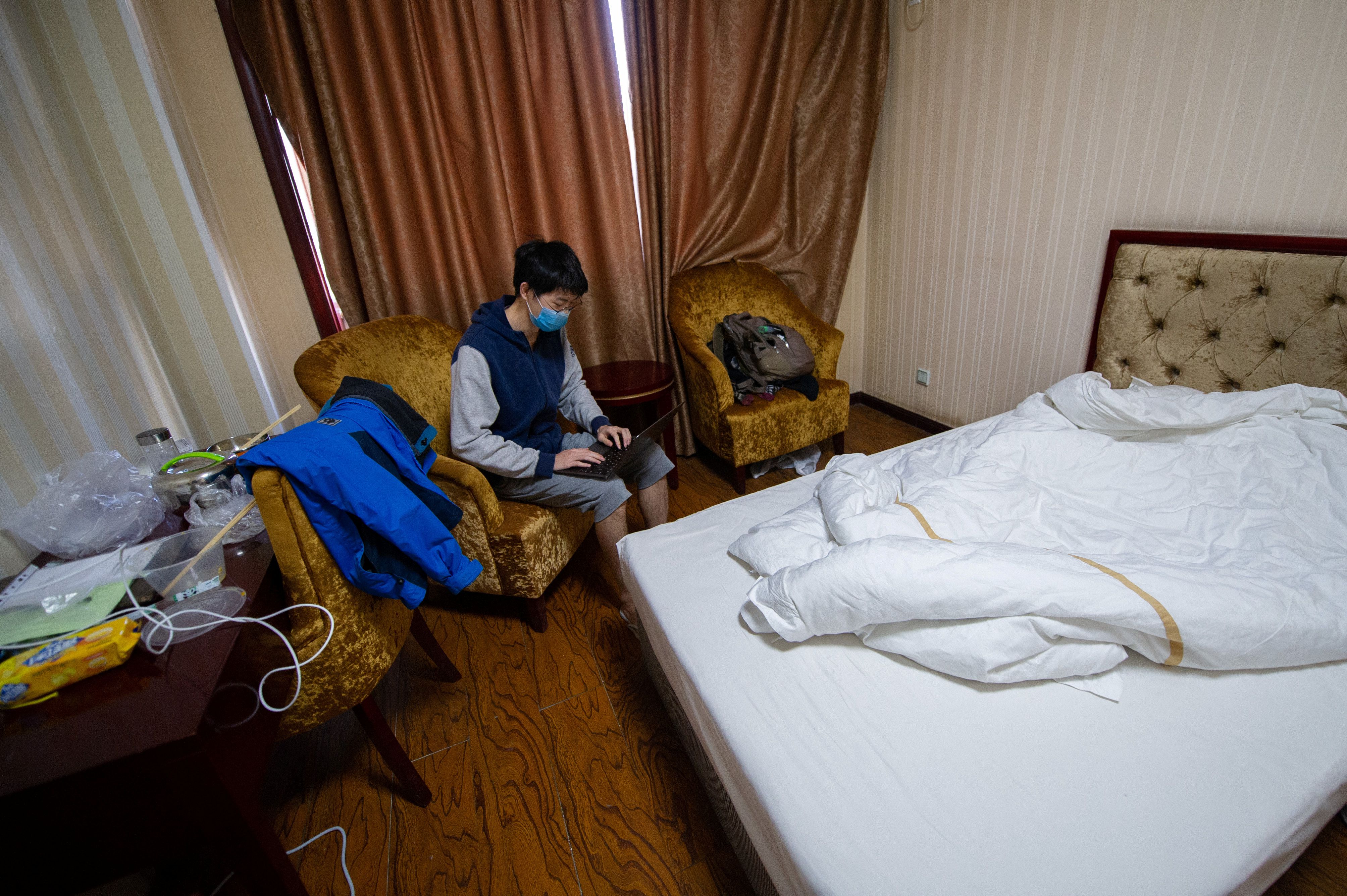 Overseas Chinese student uses a laptop at a room inside a hotel being used for centralized quarantine following an outbreak of the novel coronavirus in the country, in Taiyuan, Shanxi