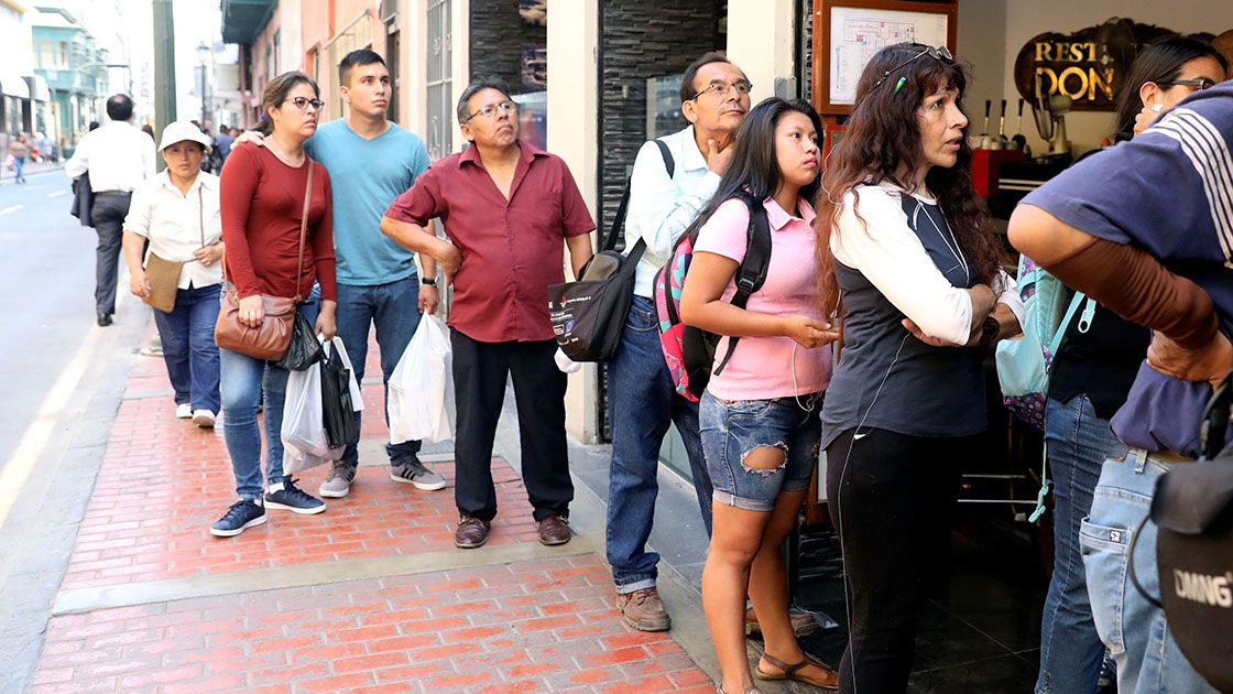 People look on as Peru's President Pedro Pablo Kuczynski addresses the nation as he resigns, in Lima