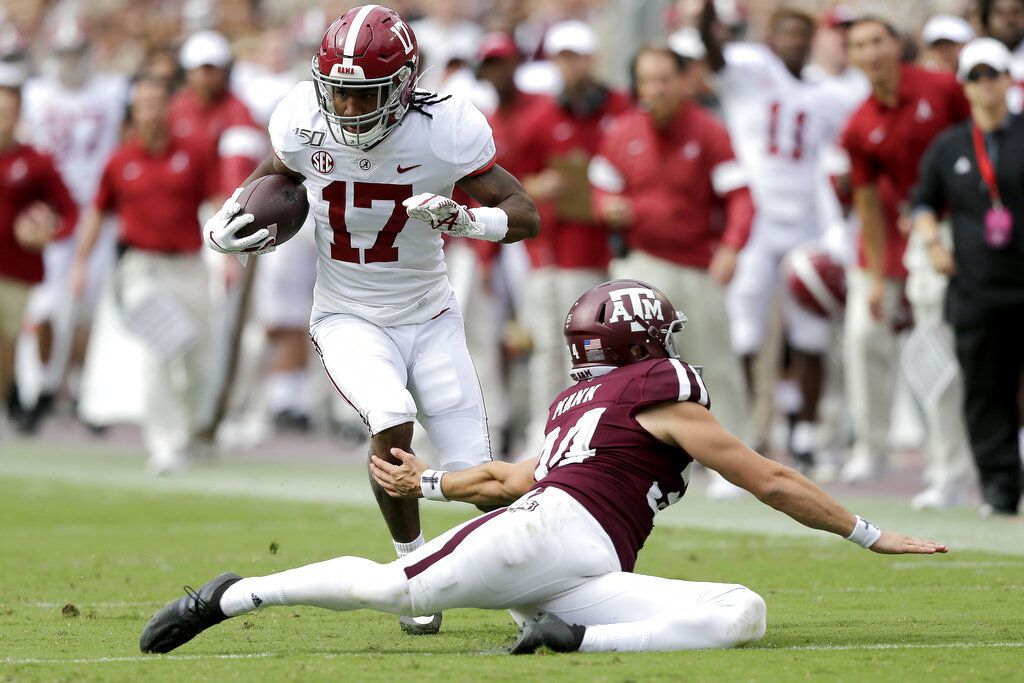 FILE - In this Saturday, Sept. 26, 2020, file photo, Alabama wide receiver Jaylen  Waddle, center, pulls down a reception between Missouri's Tyree Gillespie,  right, and Ishmael Burdine, left, during the first