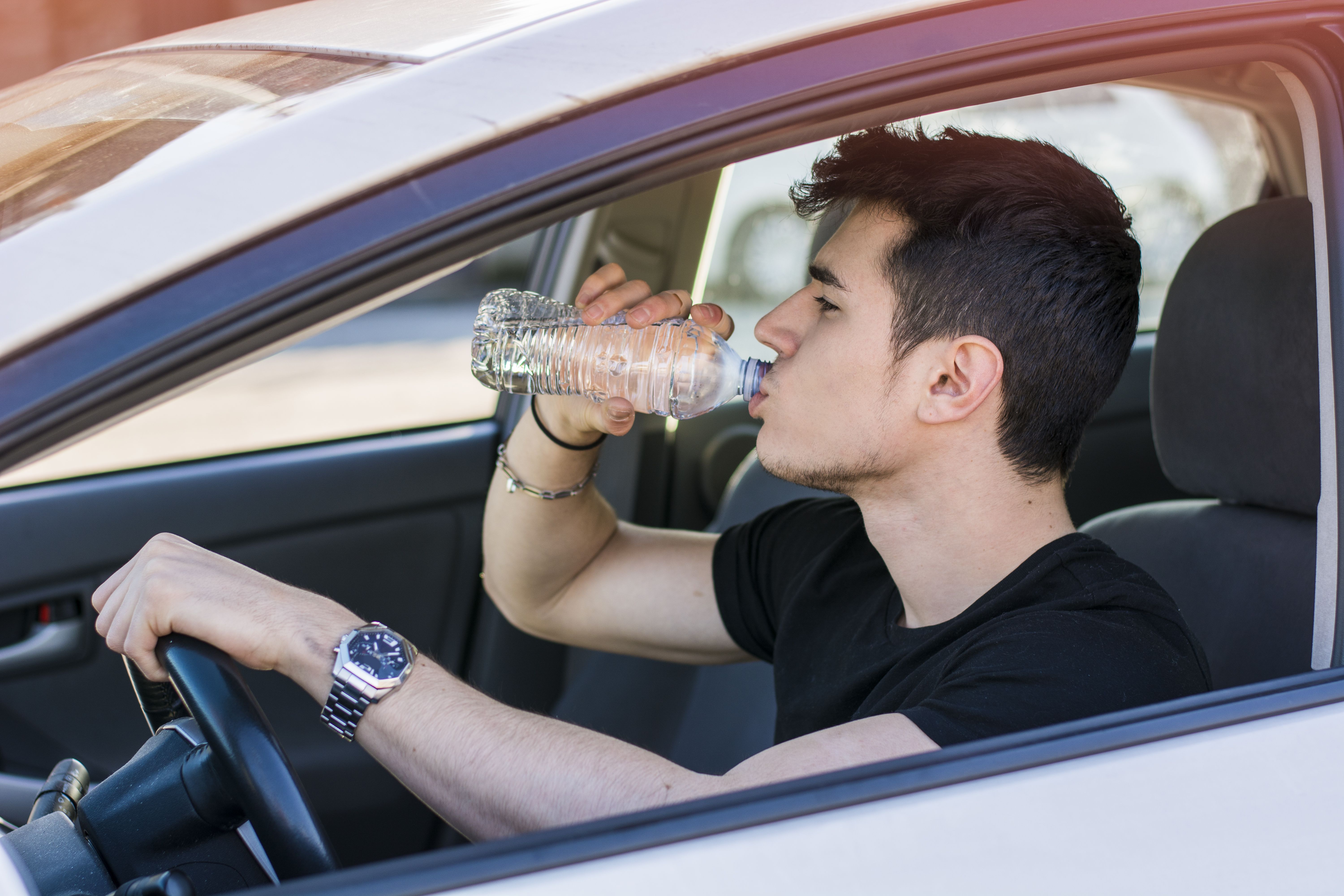 iStock-474741284-Driving-Car-Drinking-From-Plastic-Water-Bottle.jpg