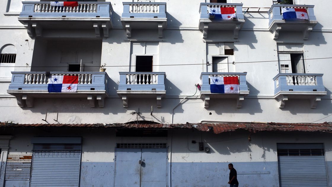 A man walks by a building decorated with Panamanian national flags du