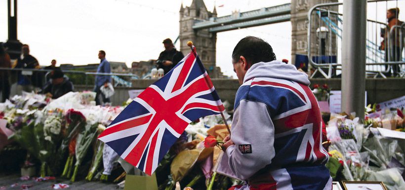 a-man-holds-a-union-flag-as-he-kneels-near-37947038